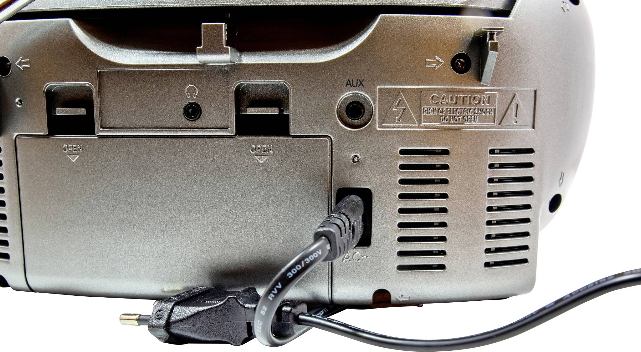 Unterseite eines elektronischen Geräts mit mehreren Anschlüssen, darunter ein AUX-Eingang und ein Netzkabel, das angeschlossen ist.