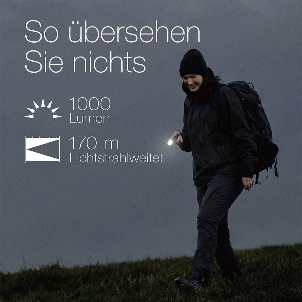 Person mit Taschenlampe unterwegs. Text beschreibt Lichtleistung: 1000 Lumen und Reichweite: 170 m. Überschrift: So übersehen Sie nichts.