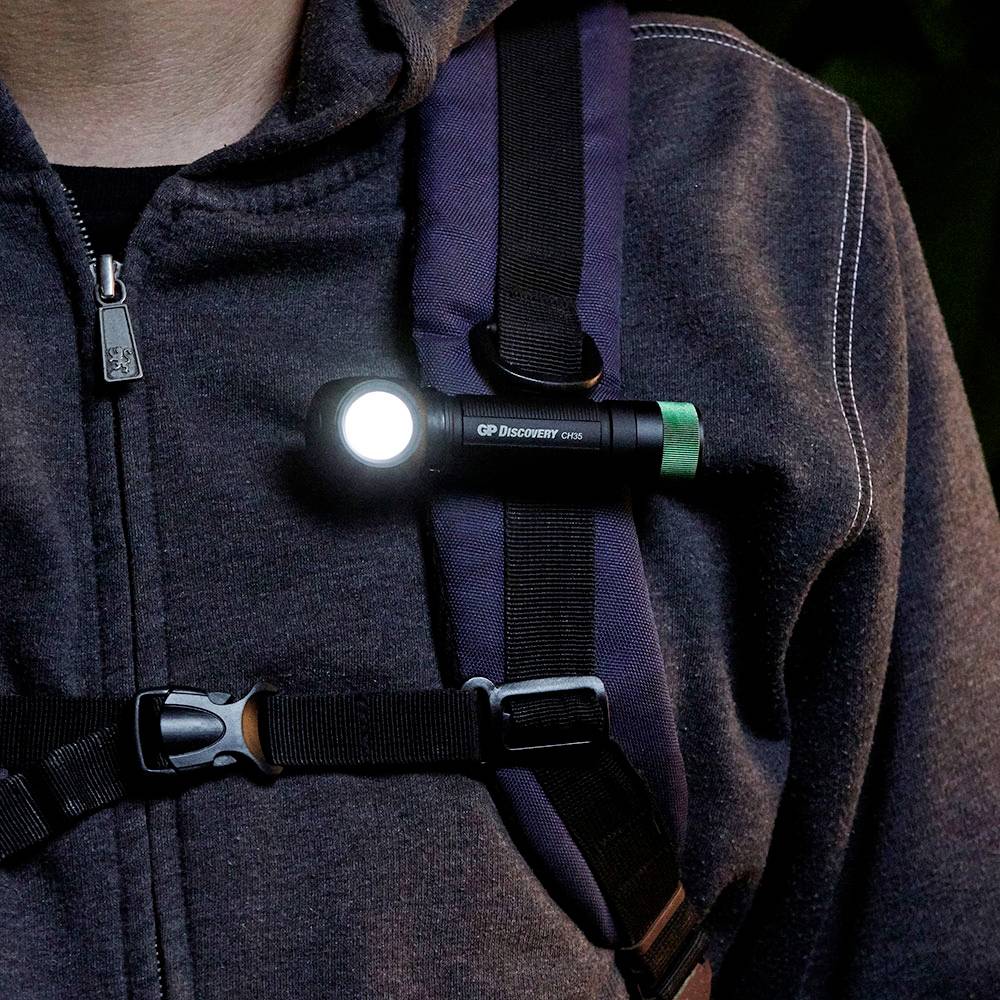 Eine Person trägt eine graue Jacke mit einer am Gurt befestigten Taschenlampe, die leuchtet.