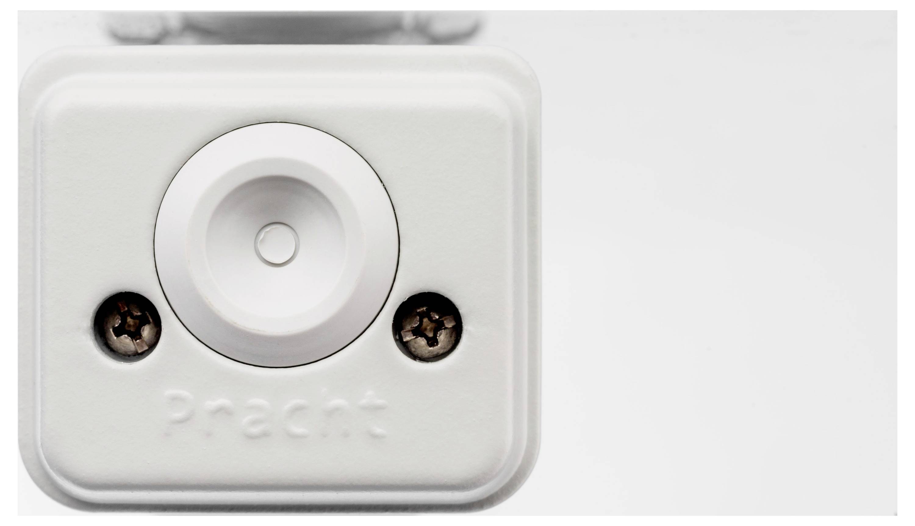 Weiße rechteckige Box mit Knopf in der Mitte, darunter Schriftzug 'Pracht'.