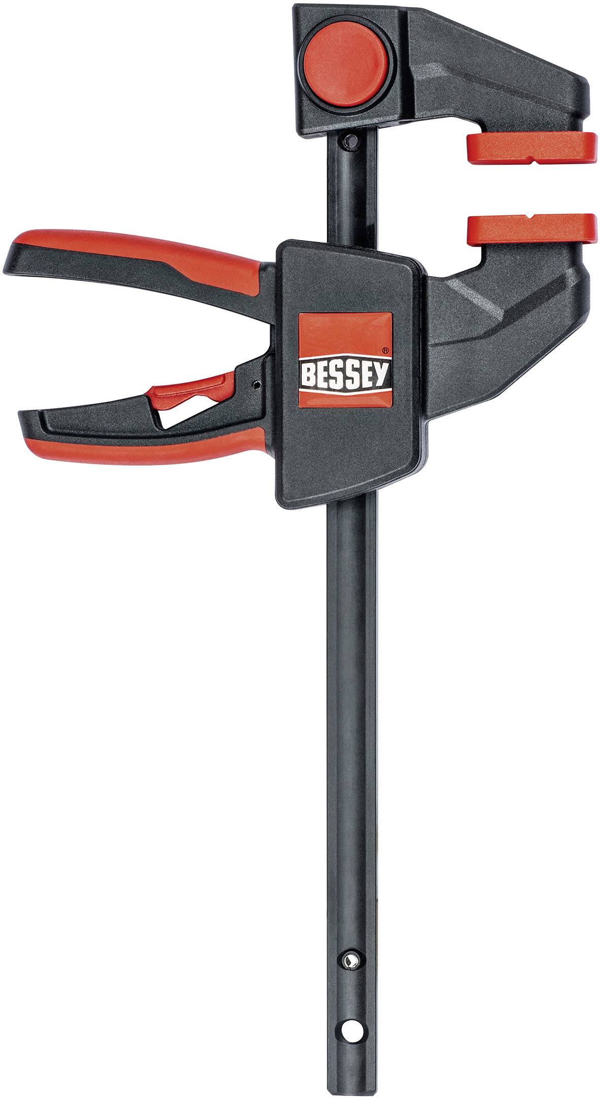 Eine schwarze Zwinge mit roten Griffen und der Marke 'BESSEY', verwendet zum Festhalten von Materialien bei Holzarbeiten oder Bauprojekten.