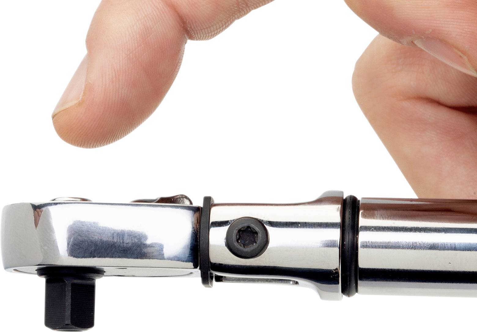 Nahaufnahme einer Hand, die einen verchromten Drehmomentschlüssel an einem schwarzen Schraubenkopf hält. Präzisionswerkzeuganwendung.