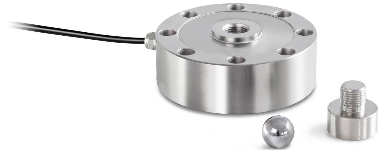 Ein zylindrischer Metall-Drucksensor mit Kabel, daneben eine Metallkugel und ein Adapter.