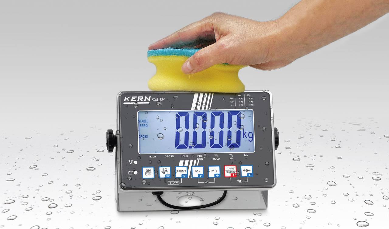 Eine Hand wäscht ein digitales Messgerät mit einem nassen Schwamm. Das Gerät zeigt '0.000 kg' auf einem großen, klaren Display.