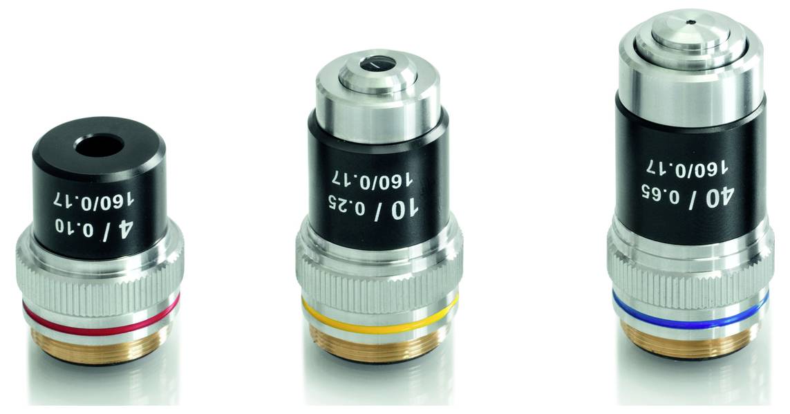 Drei Mikroskopobjektive in verschiedenen Größen und Farben: Rot (4x), Gelb (10x) und Blau (40x), auf hellem Hintergrund.