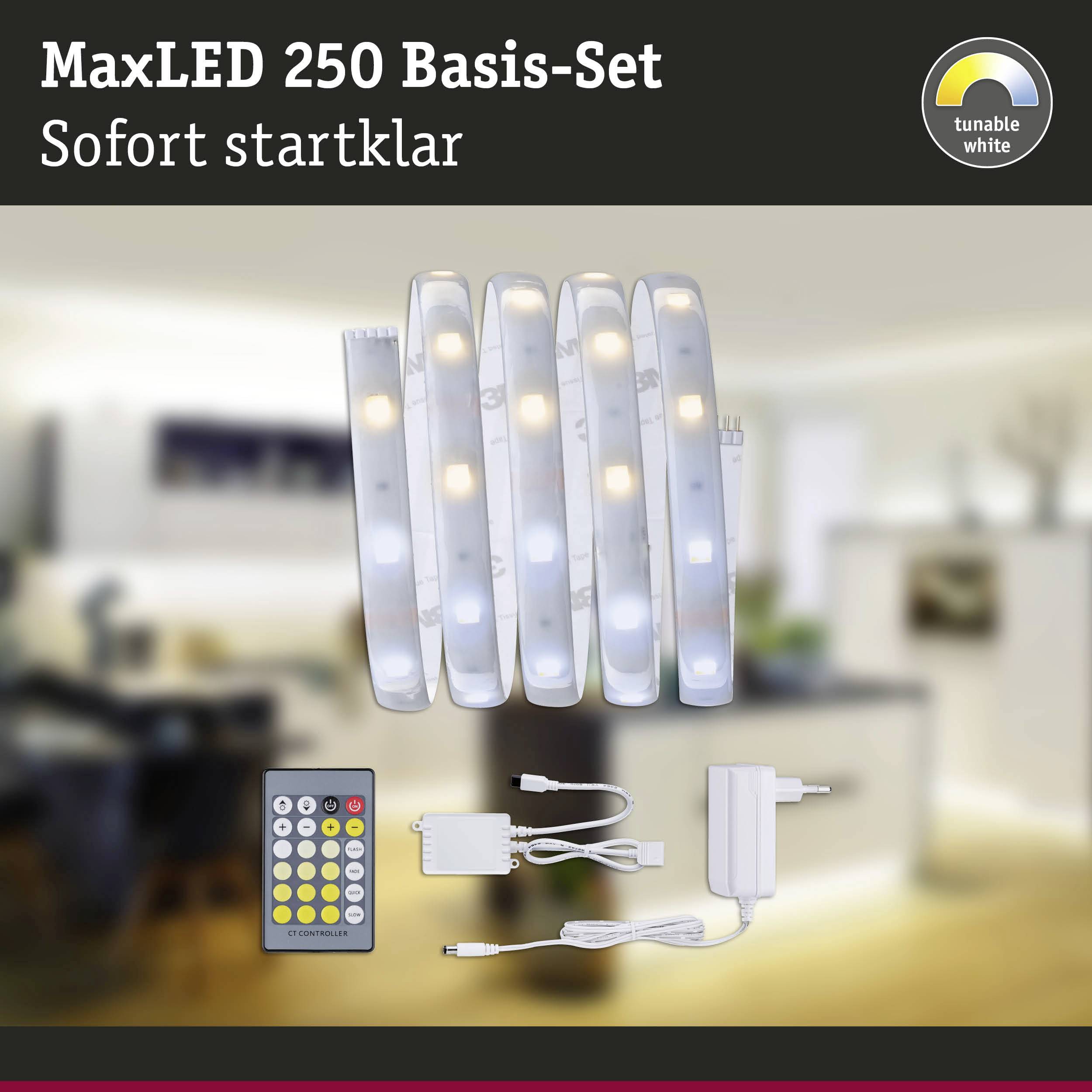 'MaxLED 250 Basis-Set' mit Fernbedienung und Netzteil auf einem Tisch. Text oben: 'Sofort startklar'. Rückansicht eines unscharfen Wohnzimmers.