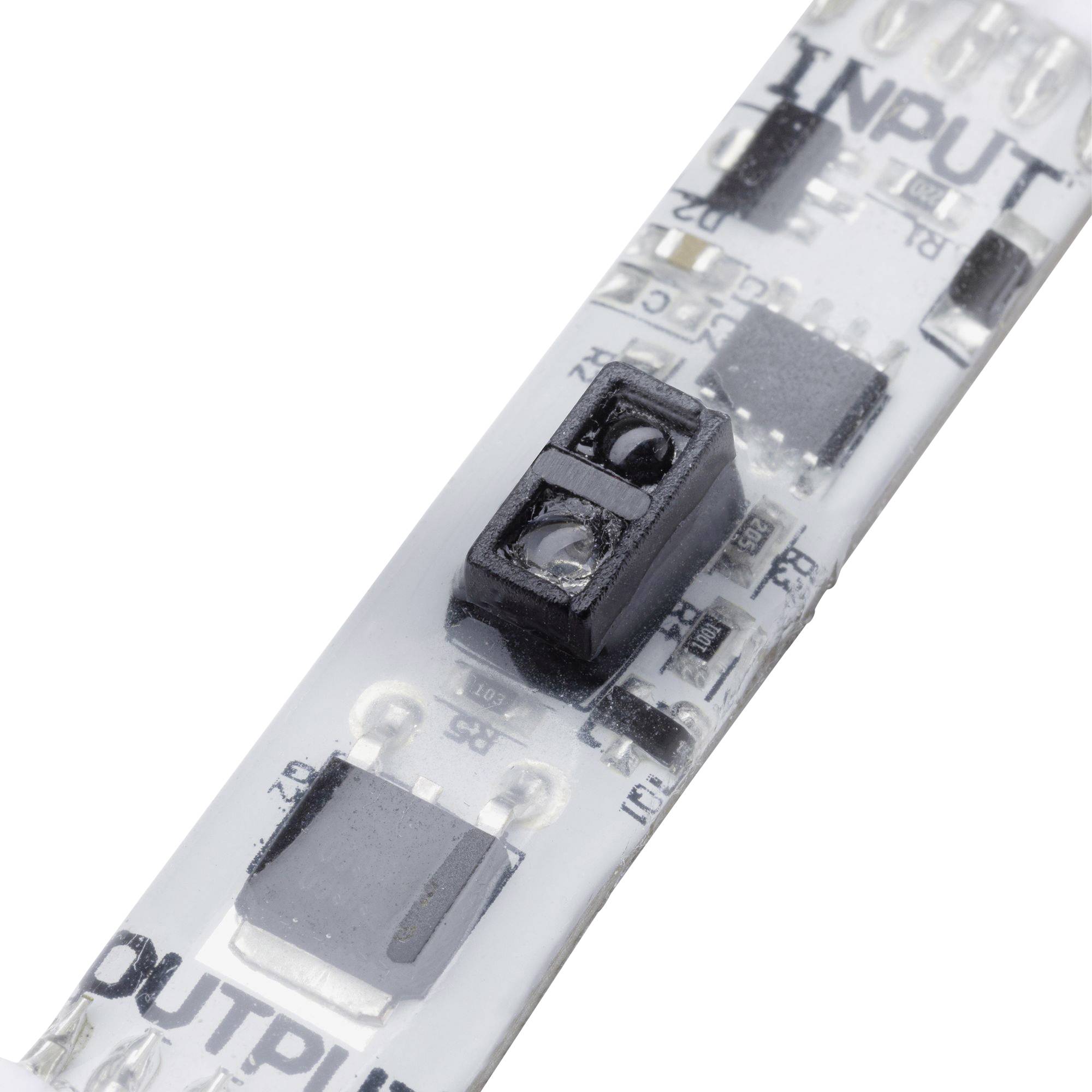 'Nahaufnahme einer LED-Streifenplatine mit elektronischen Bauteilen, Aufschrift INPUT und OUTPUT sichtbar. Hauptplatine in Weiß.',