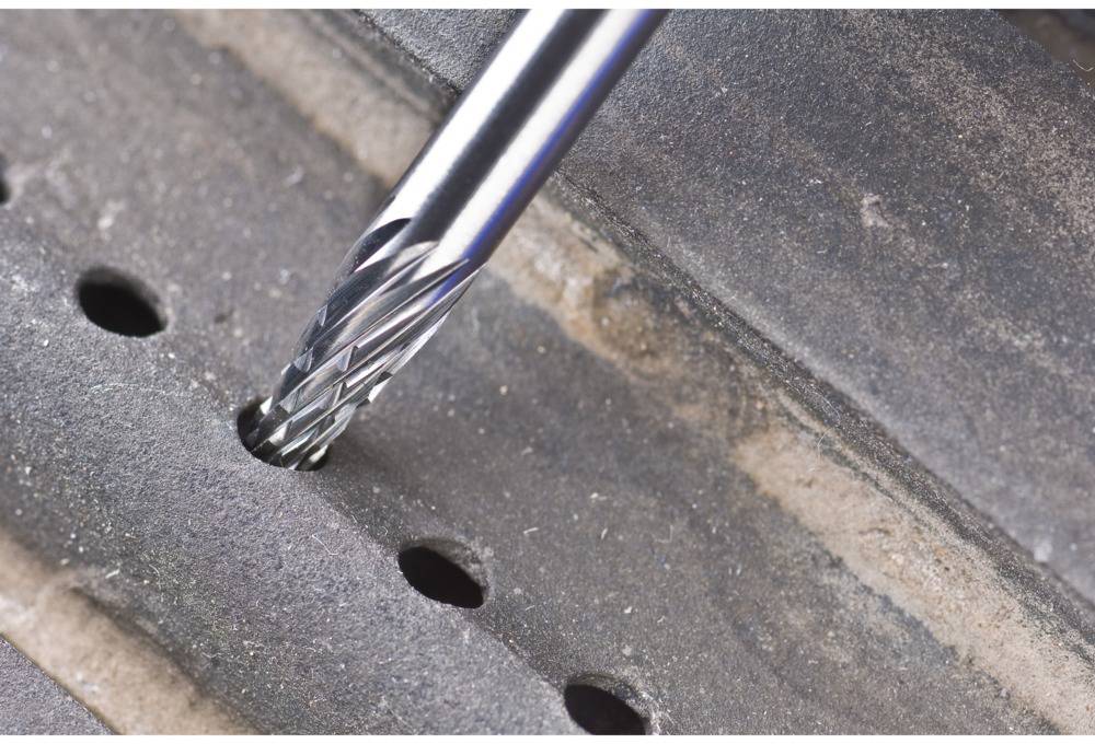 Nahaufnahme eines Bohrers, der ein Loch in ein Metallstück bohrt.