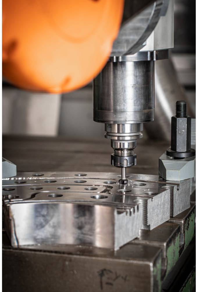 Eine CNC-Fräsmaschine bearbeitet ein Metallteil, zeigt Präzision in der Metallbearbeitung.