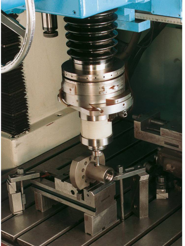 Eine CNC-Maschine bearbeitet ein Metallwerkstück auf einem Frästisch. Die Szene zeigt die präzise Ausrichtung und Bearbeitung des Materials.