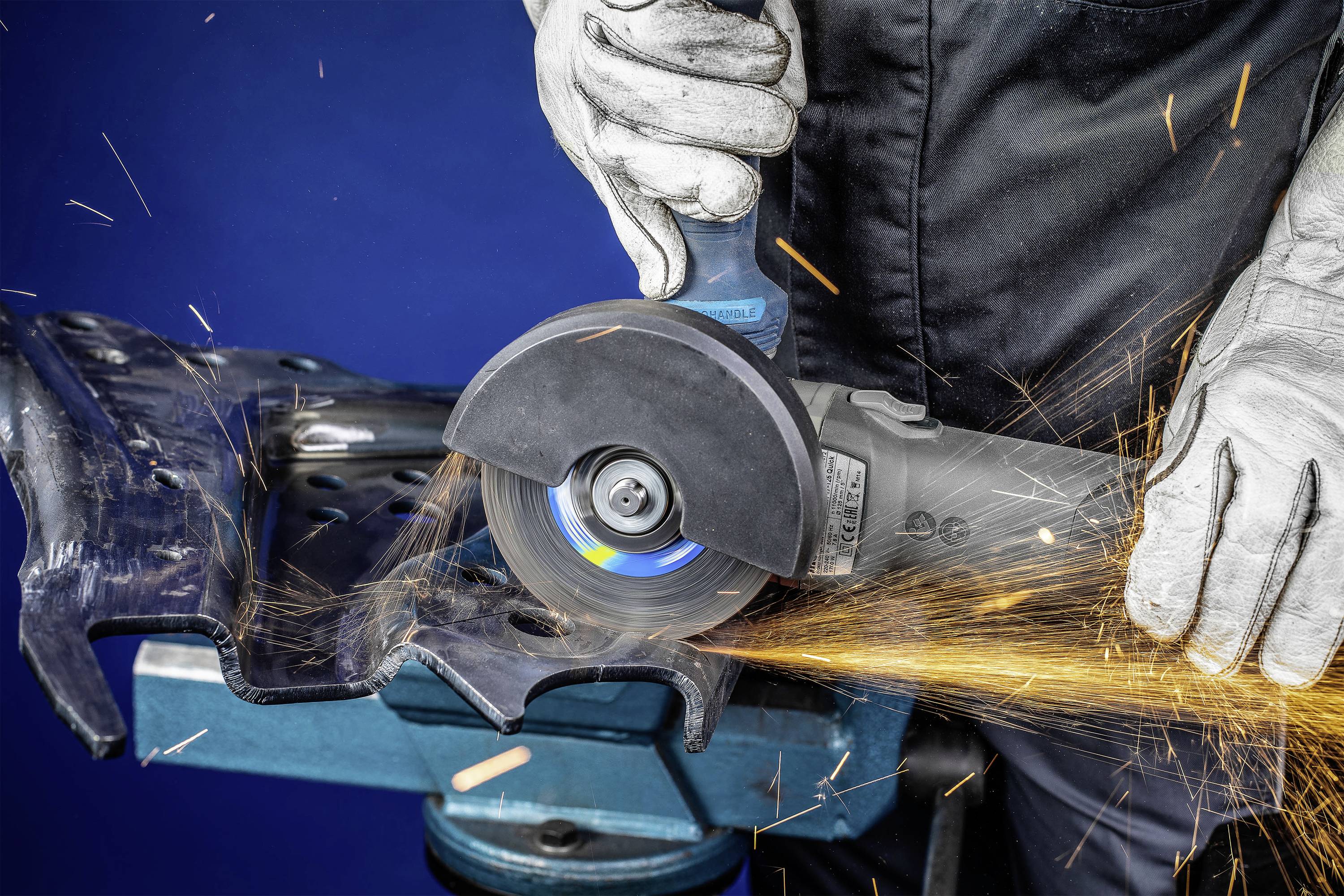 Handwerkliche Tätigkeit: Eine Person schneidet mit einem Winkelschleifer Metall, während Funken sprühen. Sie trägt Sicherheitshandschuhe.