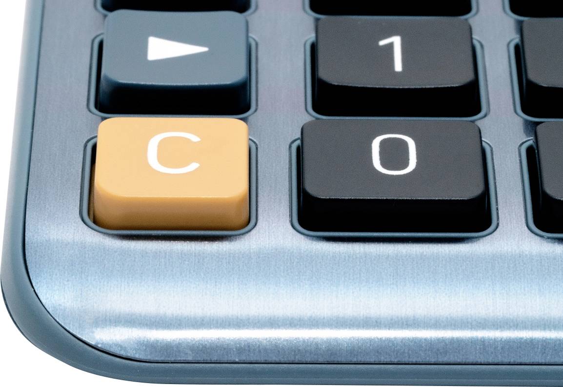 Eine Detailaufnahme einer Taschenrechner-Tastatur mit dem orangefarbenen 'C'-Knopf hervorgehoben, umgeben von schwarzen Zahlentasten.