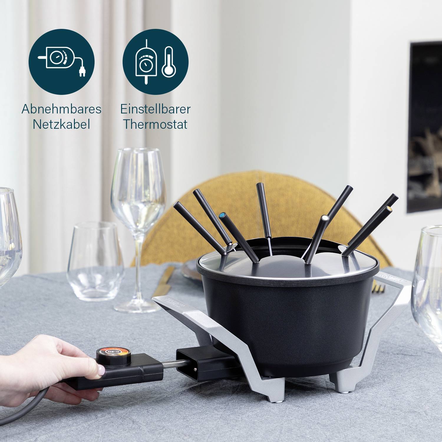 Fondue-Set auf einem gedeckten Tisch, mit verstellbarem Thermostat und abnehmbarem Netzkabel.