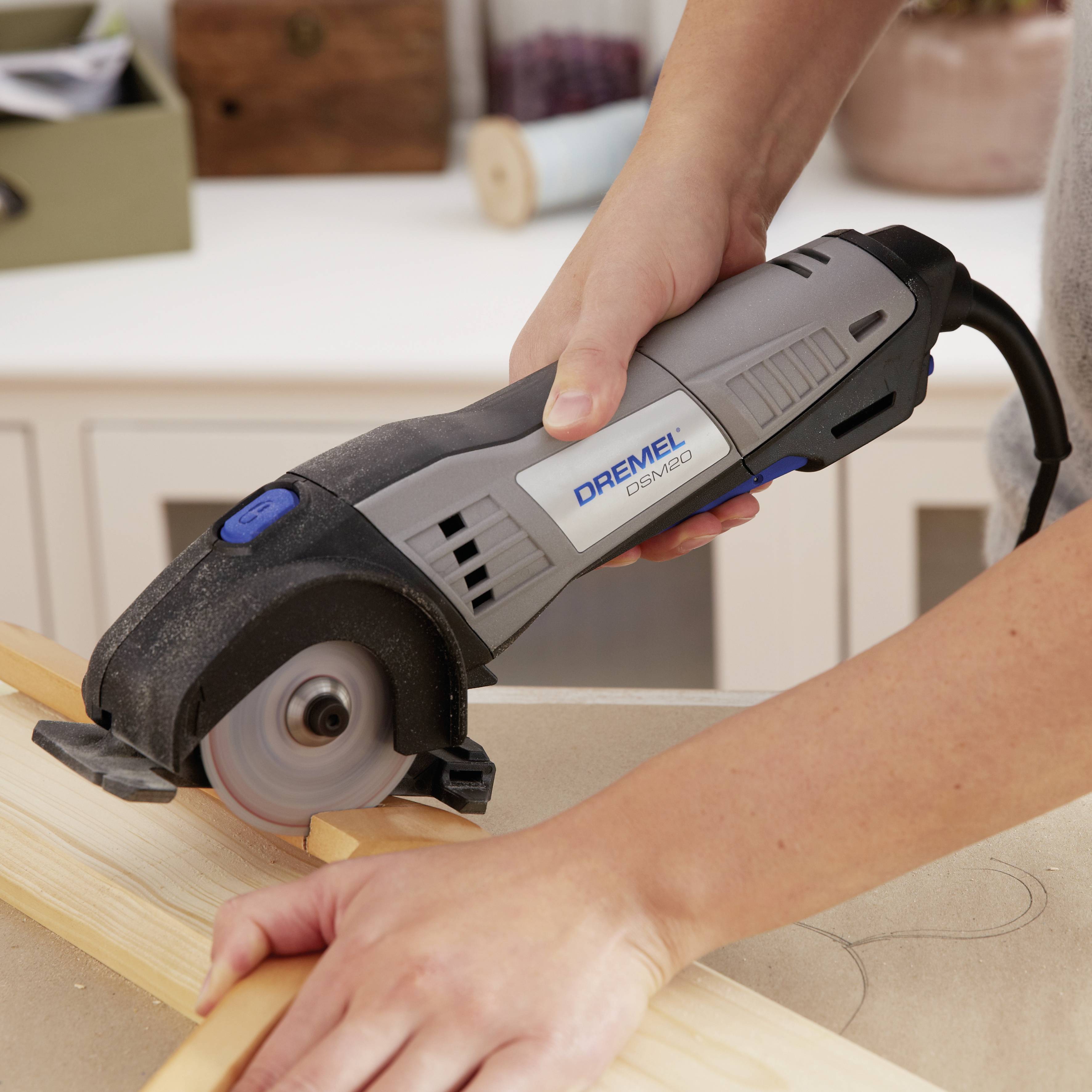 Person arbeitet mit einem elektrischen Handwerkzeug, um Holz präzise zu schneiden. Fokus auf Werkzeug und Holzstück.