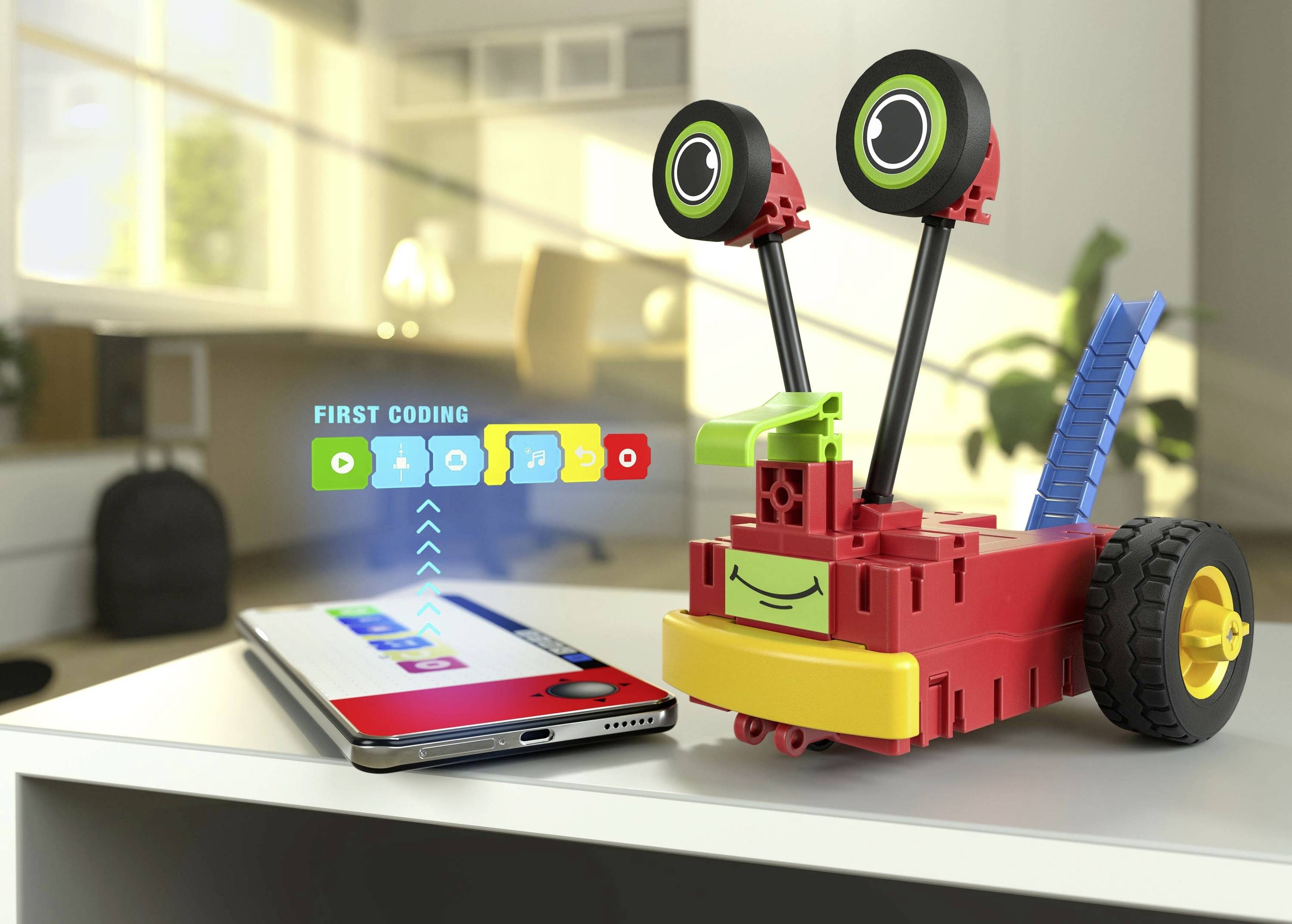 Ein buntes Roboter-Spielzeug mit Rädern, verbunden mit einem Smartphone, zeigt eine Coding-App zur Steuerung und Programmierung.