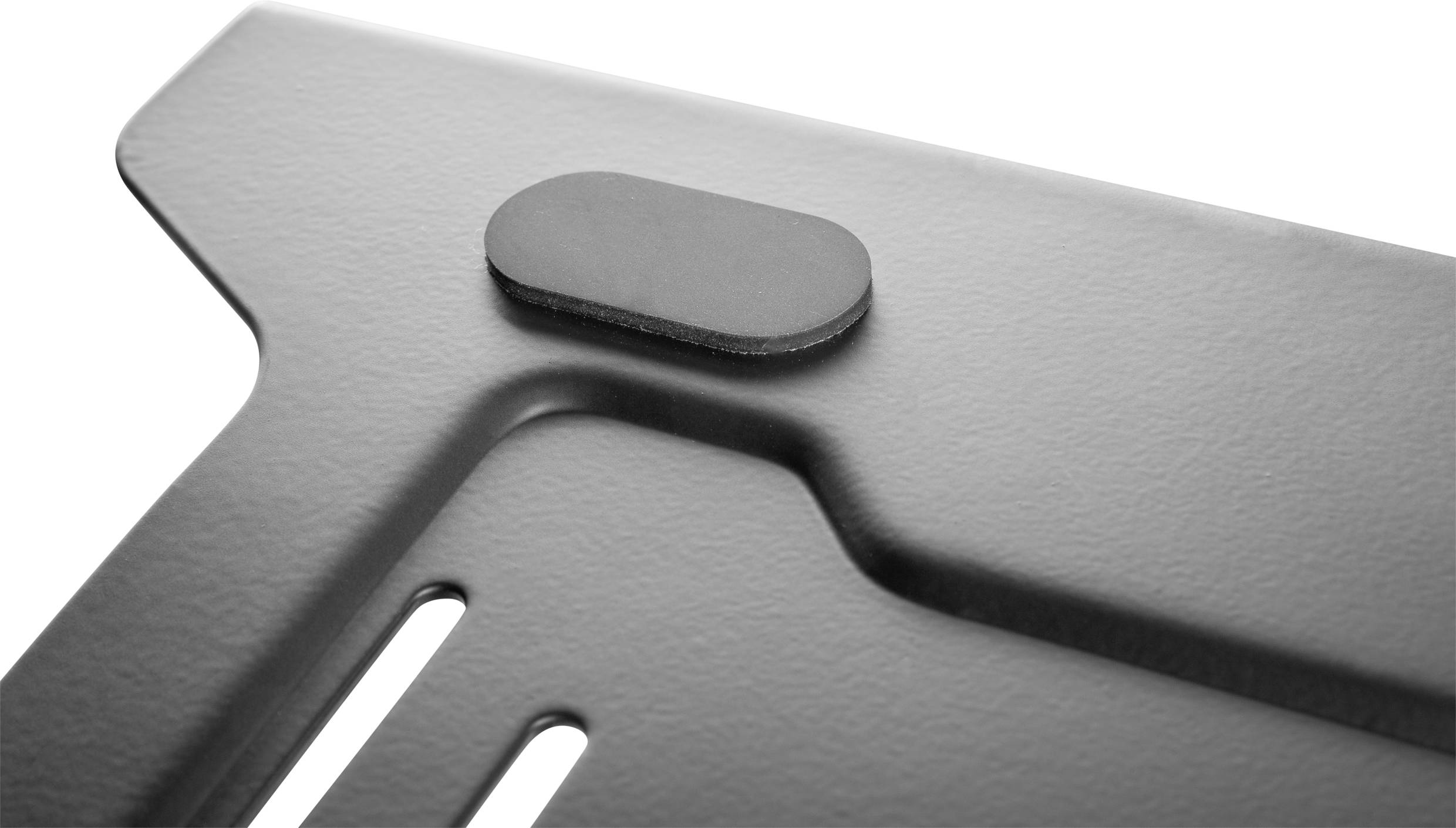 Nahaufnahme einer grauen Metalloberfläche mit einer ovalen Erhebung. Die Struktur wirkt industriell und schlicht.