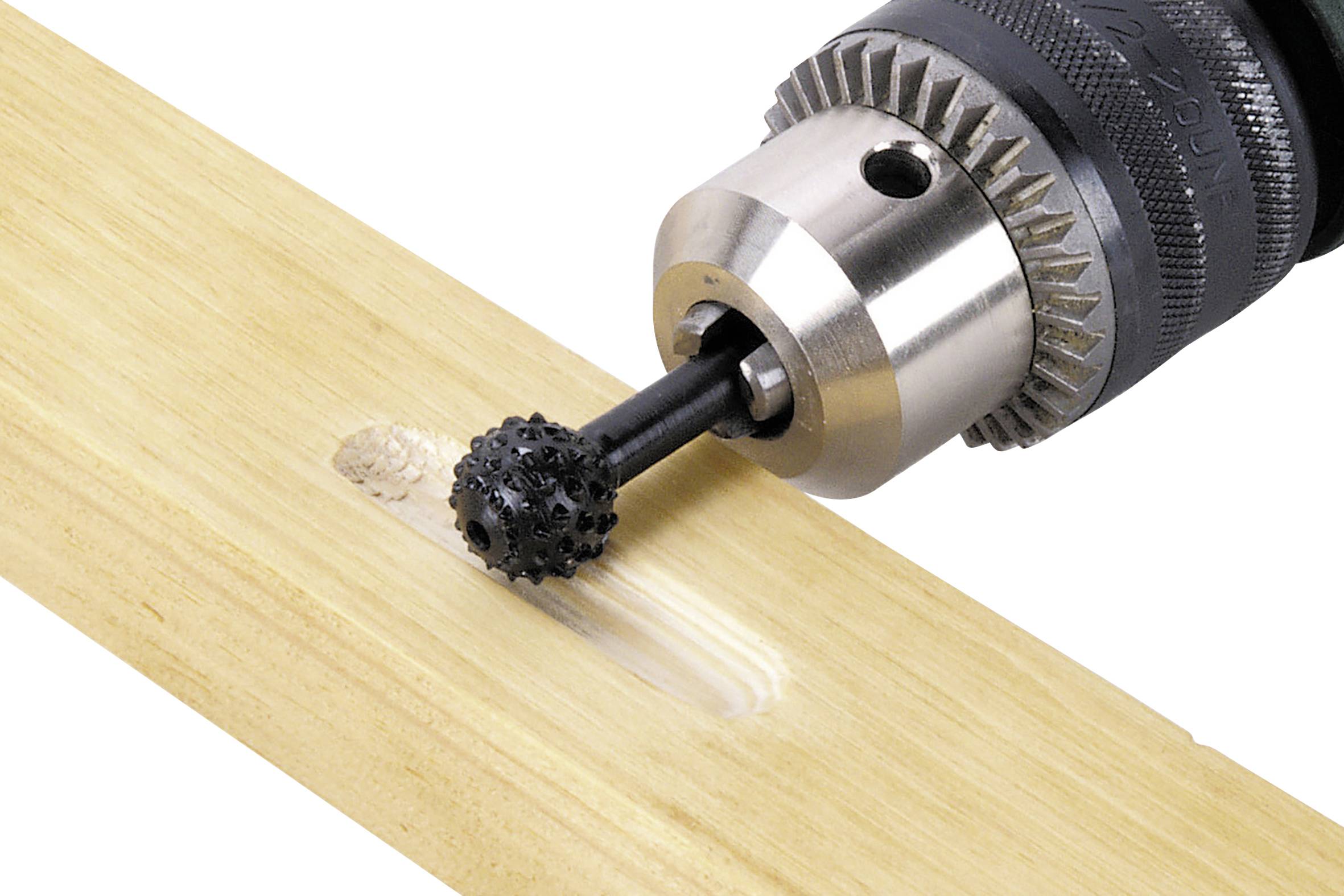 Eine elektrische Bohrmaschine bearbeitet ein Stück Holz, wobei ein schwarzer Schleifkopf ein Loch fräst.