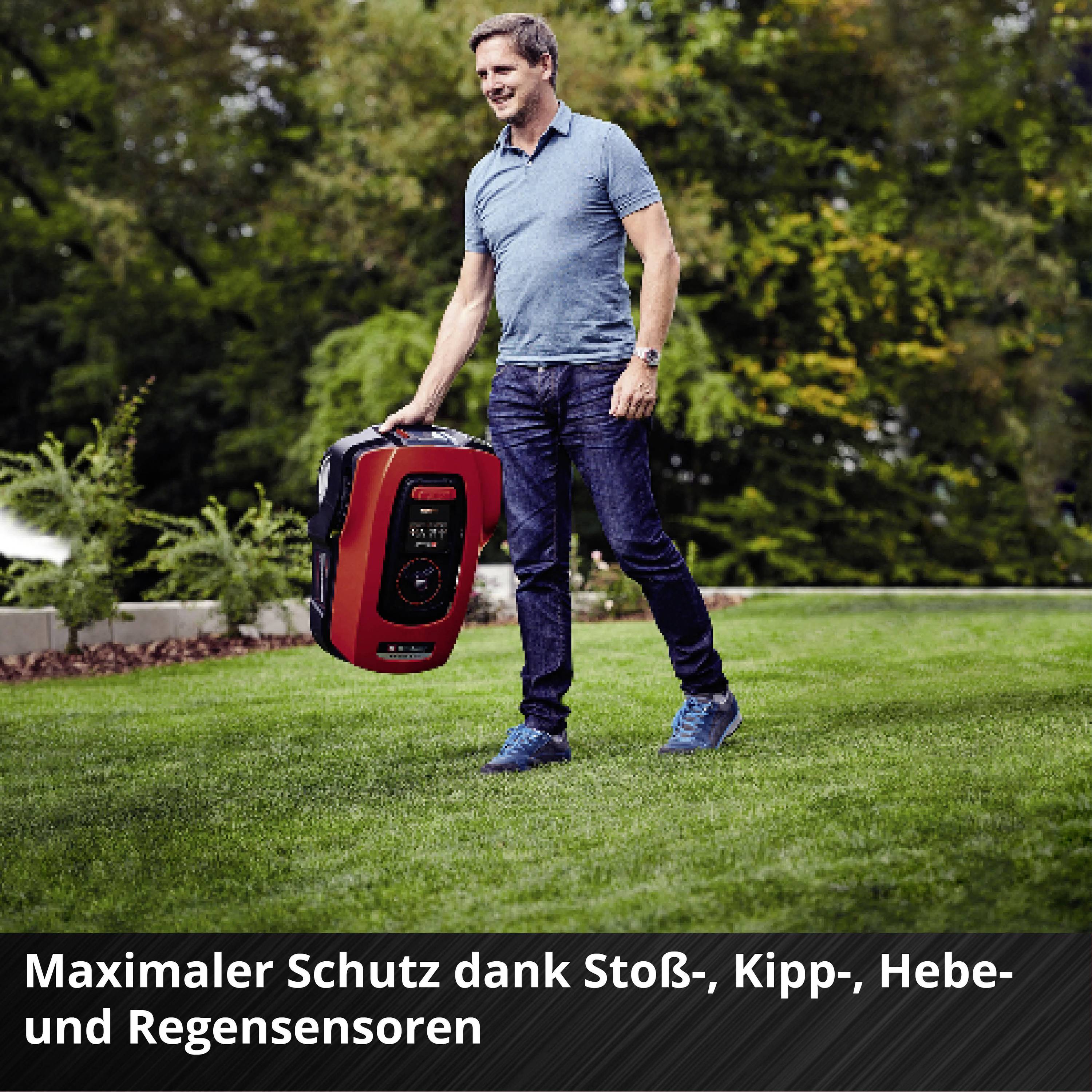 Mann in Polohemd steht auf Rasen und hält einen Rasenroboter. Text im Bild: 'Maximaler Schutz dank Stoß-, Kipp-, Hebe- und Regensensoren'.