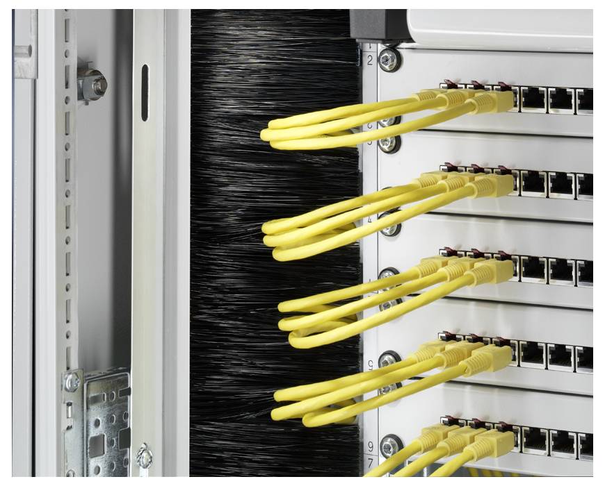 Ein Netzwerk-Rack mit mehreren gelben Ethernet-Kabeln, die in einen Patch-Panel eingesteckt sind, zeigt die Organisation von Datenverbindungen.