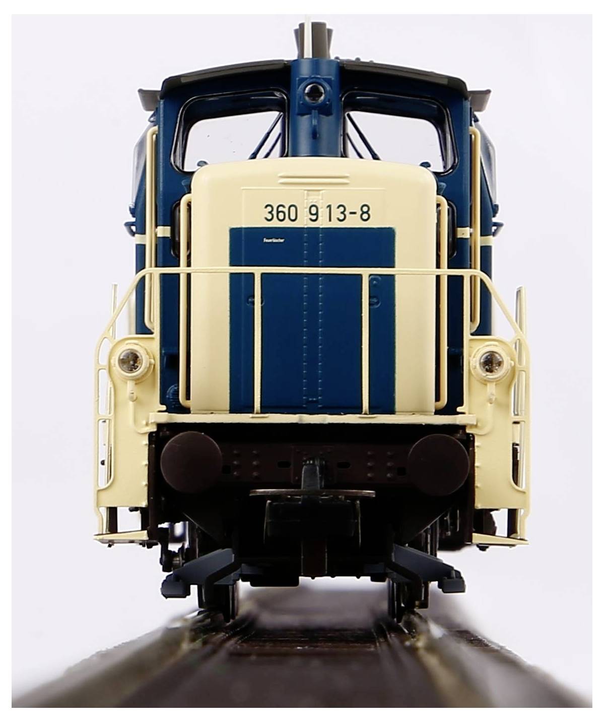 Eine Modelllokomotive in blau und beige von vorne, zeigt die Nummer '360 913-8'. Sie steht auf einem Gleisabschnitt.