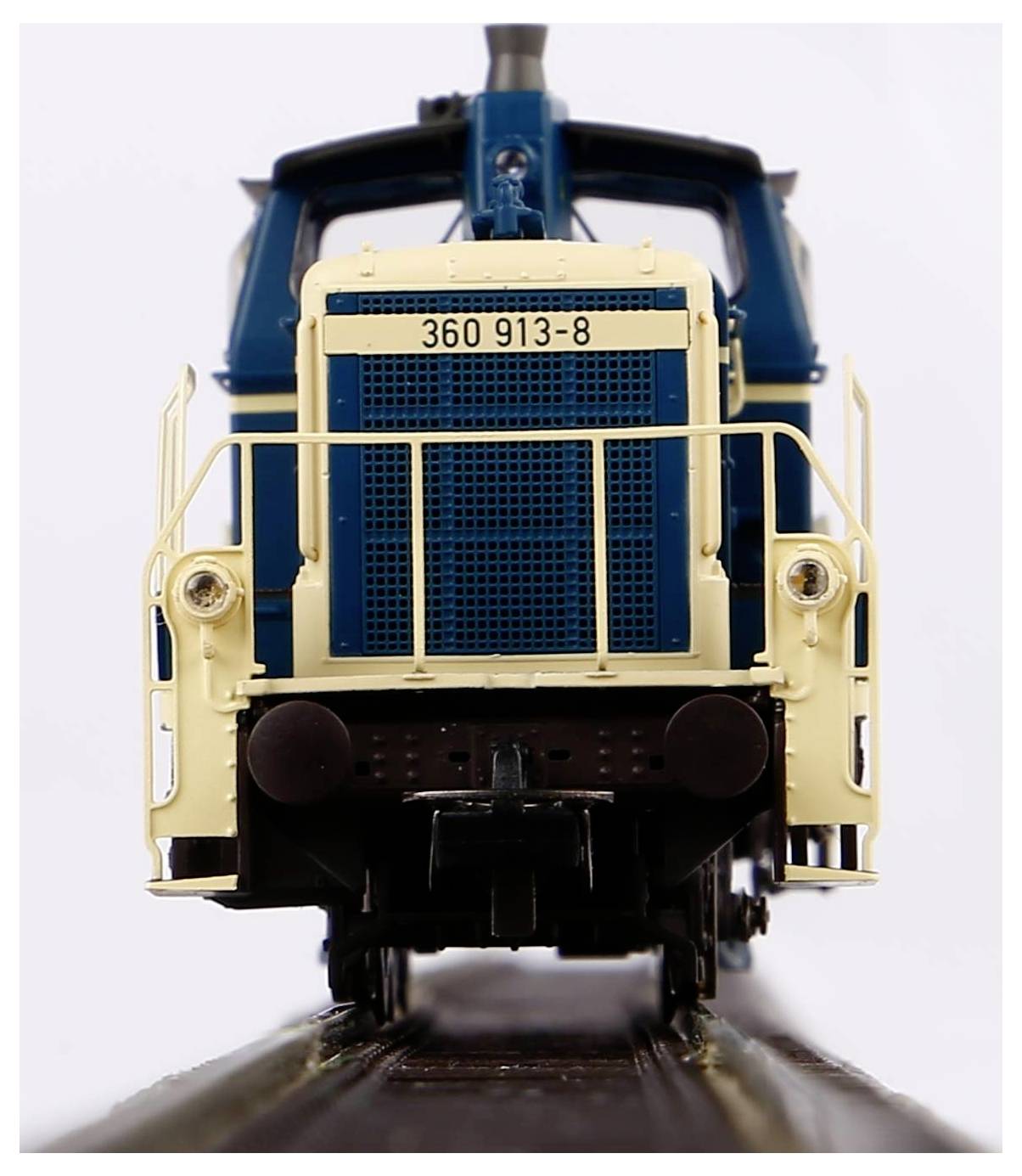 Nahaufnahme einer Modell-Lokomotive in Blau und Beige auf Gleisen, Vorderansicht. Loknummer '360 913-8'.