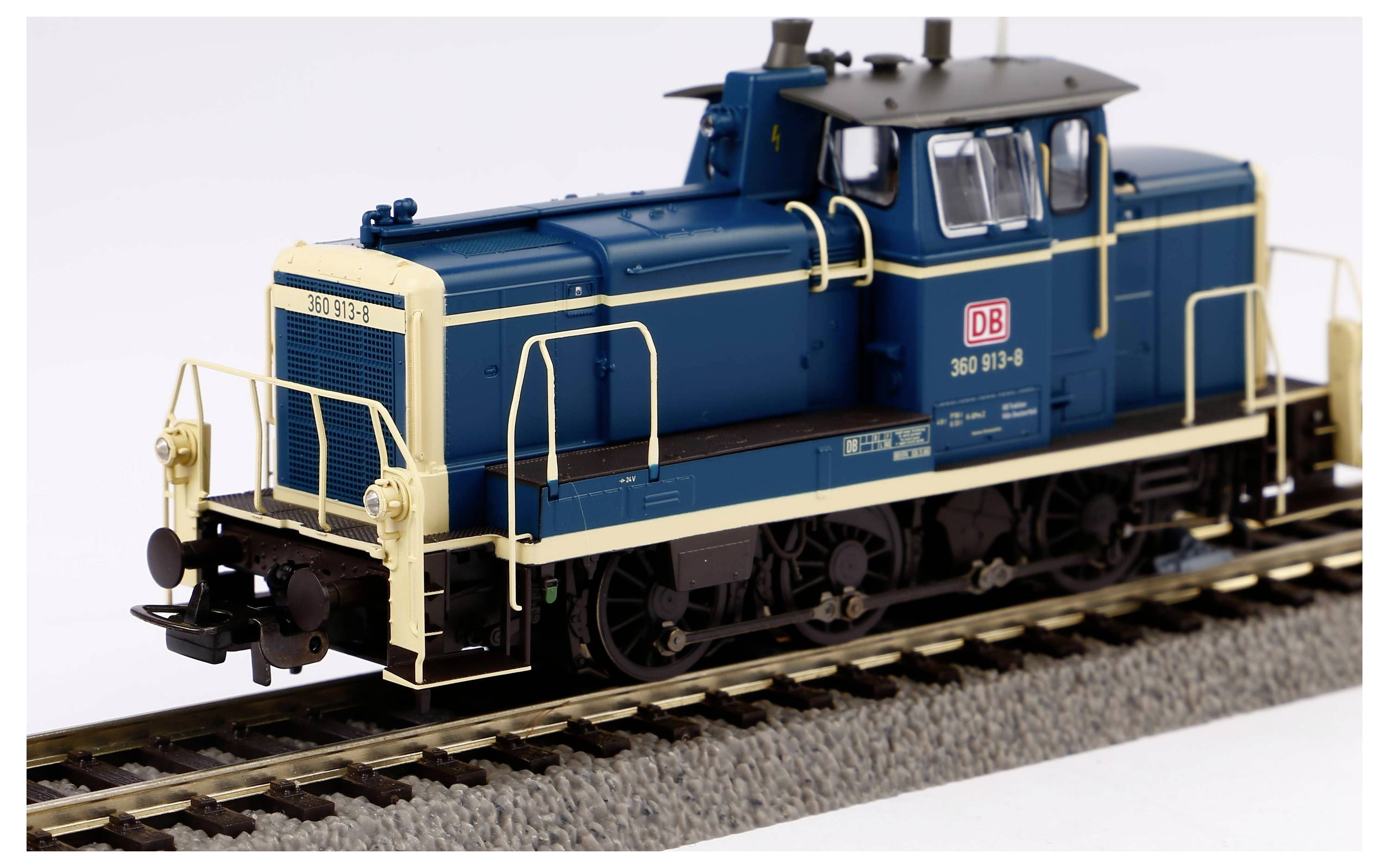 Modelleisenbahn-Lokomotive in Blau und Creme der Deutschen Bahn steht auf Gleisen. Detaillierte Darstellung mit markanten DB-Logo.