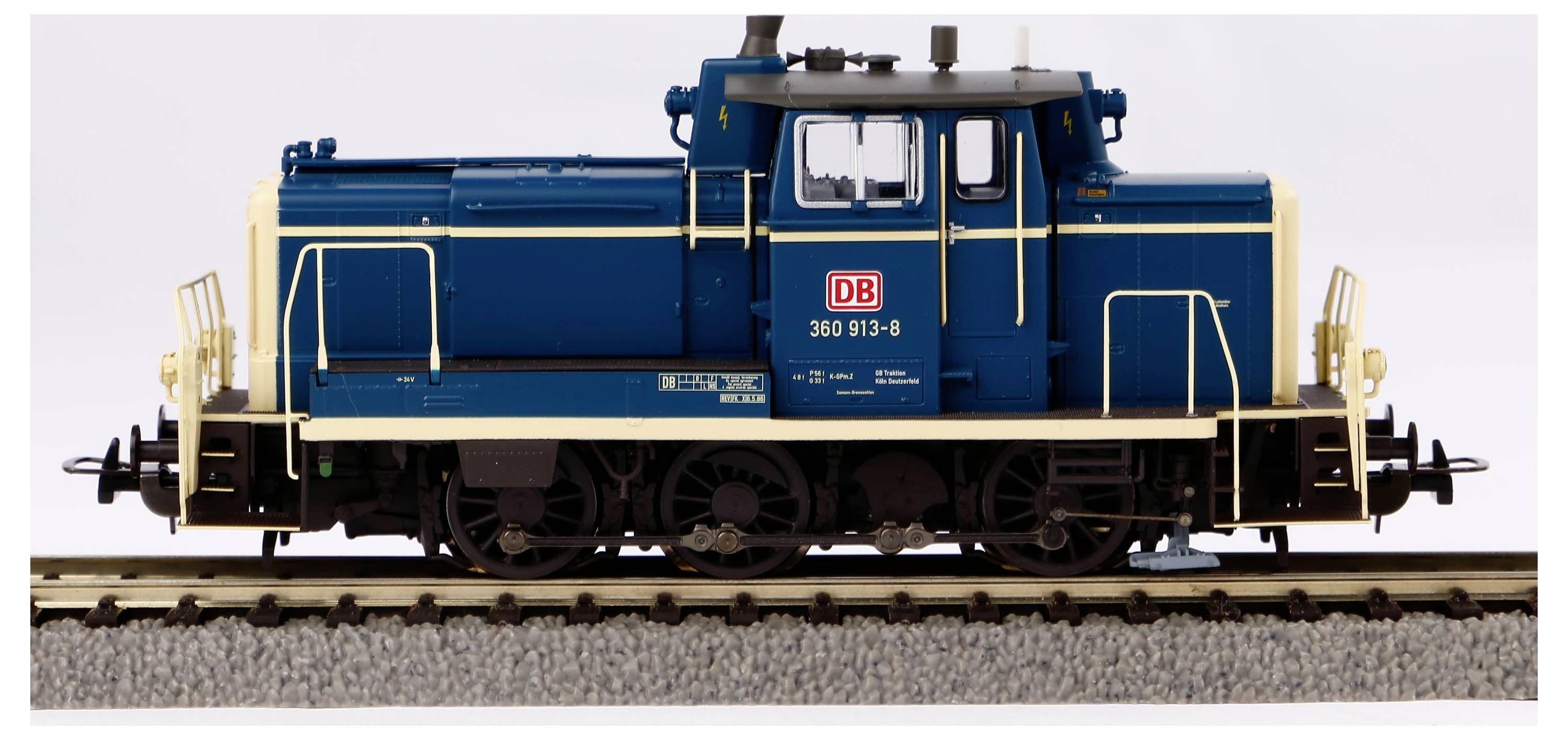 Blau-gelbe Lokomotive 360 913-8 der Deutschen Bahn auf einem Gleis, seitliche Ansicht.