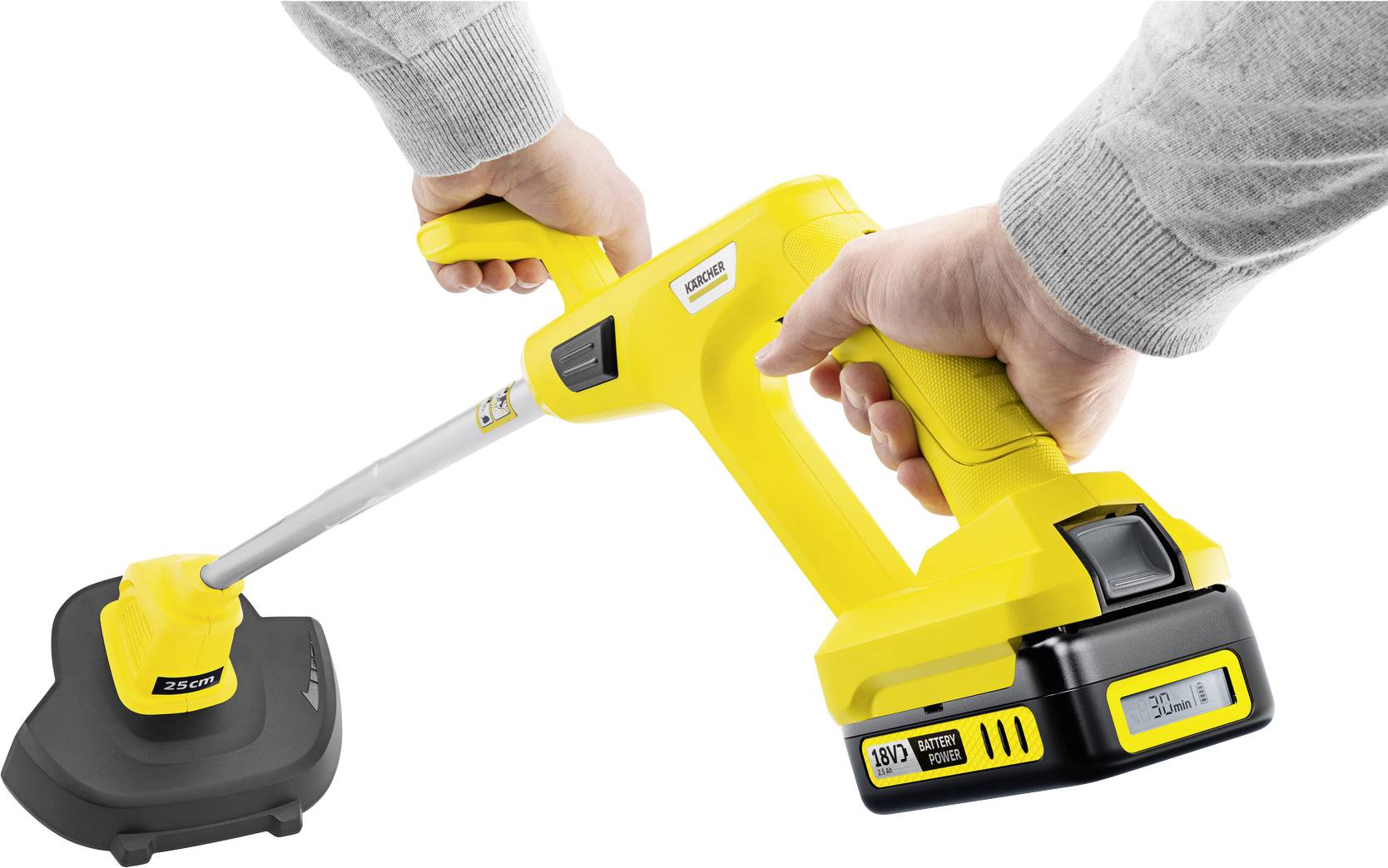Eine Person hält einen gelben, kabellosen Rasentrimmer mit ergonomischem Griff und sichtbarem Akku in der Nähe einer Ladeschale.