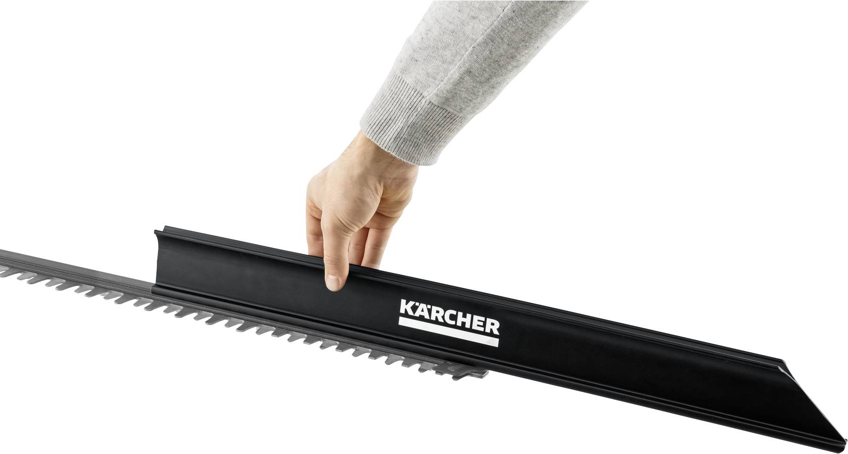 Eine Hand platziert eine schwarze Abdeckung mit 'Kärcher'-Logo über den Klingen eines Heckenschneiders, offenbar zu Schutz- oder Aufbewahrungszwecken.