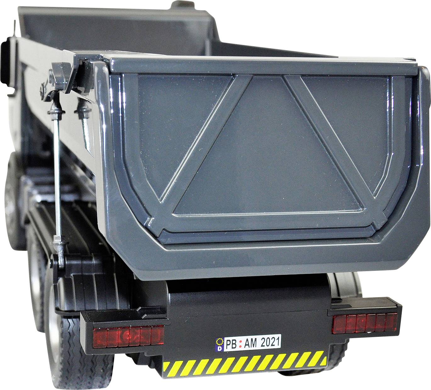 Ein grauer LKW mit offenem Ladebereich und gelbem Kennzeichen 'PB: AM 2021', steht auf einem weißen Hintergrund.