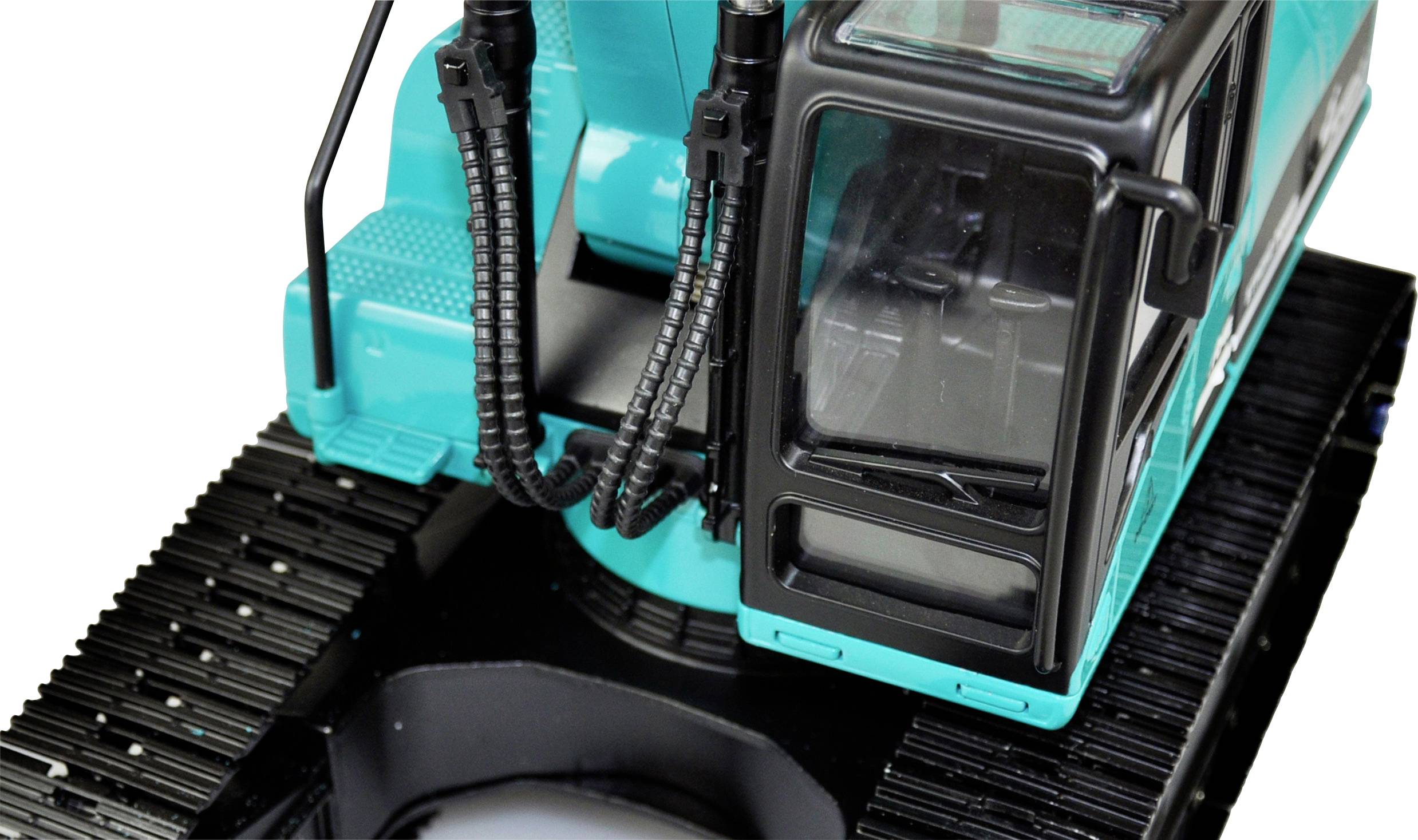 Ein türkisfarbener Spielzeugbagger mit schwarzen Ketten und einer Kabine aus durchsichtigem Kunststoff ist zu sehen.