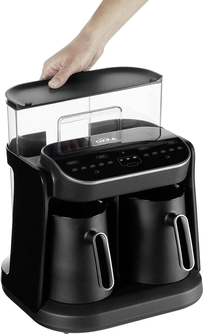 Eine Person entfernt den oberen Wasserbehälter einer modernen schwarzen Kaffeemaschine mit zwei Kaffeekannen.