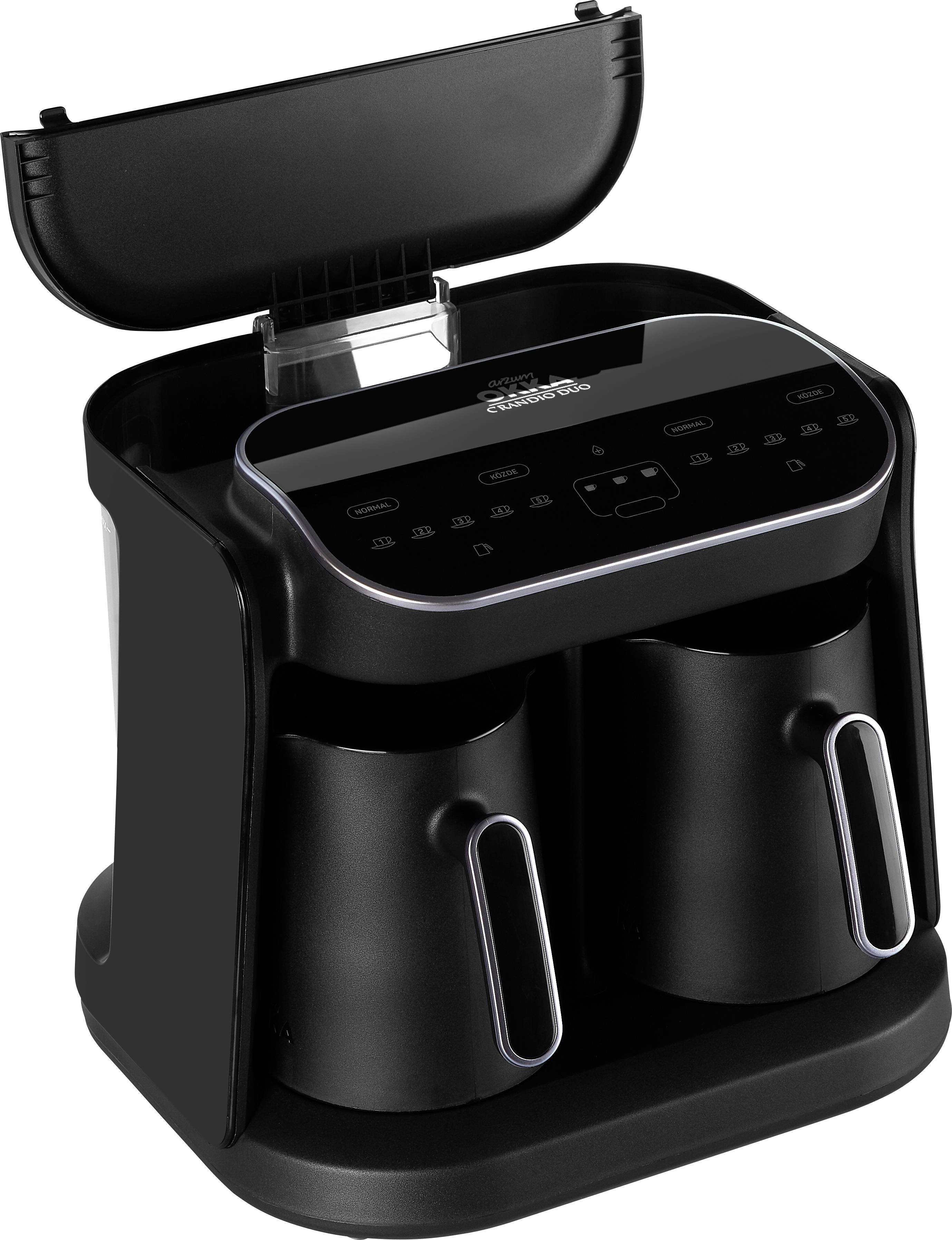 Zwei schwarze Kaffeetassen in einer modernen Kaffeemaschine mit digitalem Bedienelement.