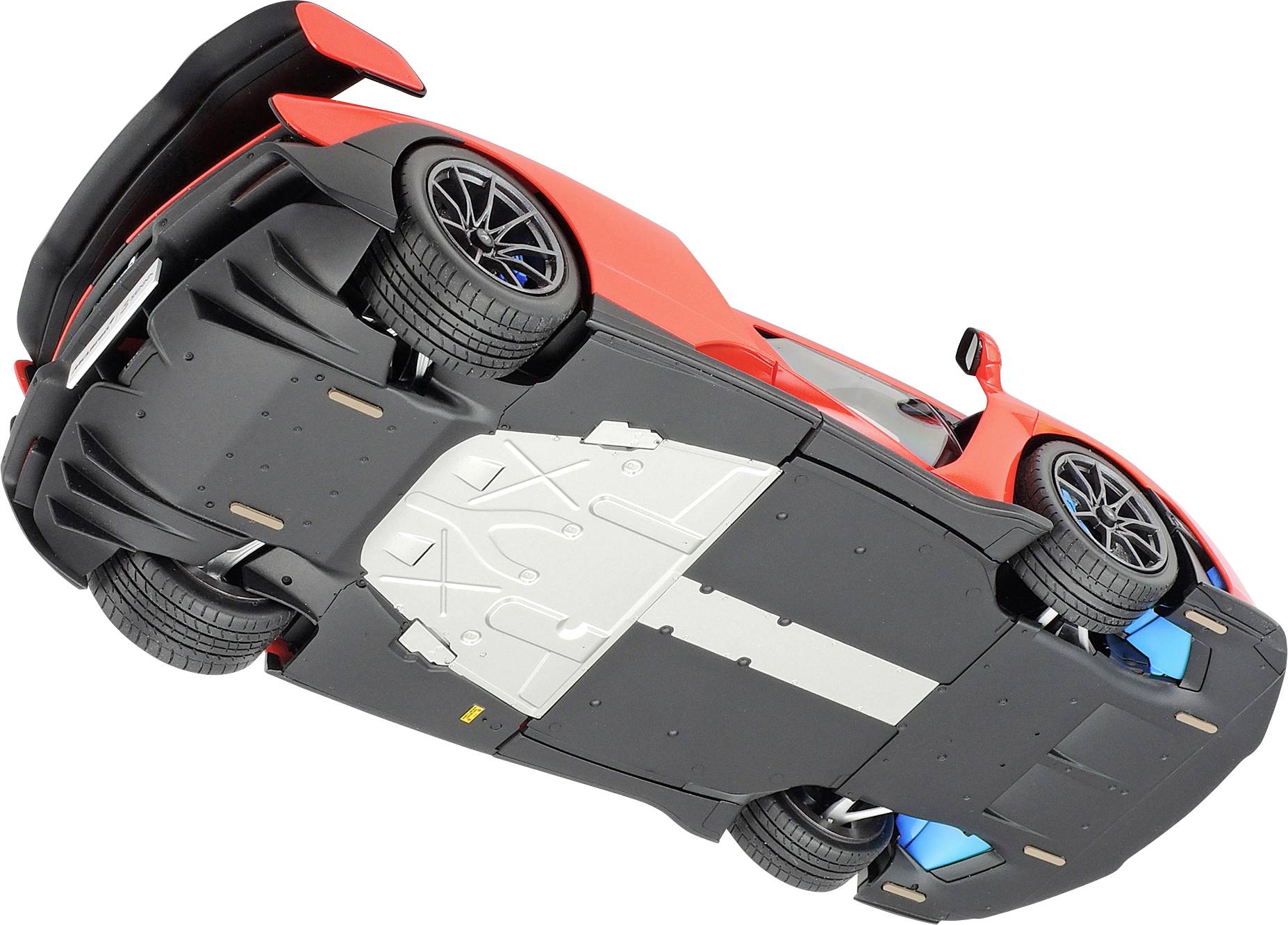 Ein rotes Sportauto von unten gezeigt, mit sichtbarem Fahrwerk und Reifenprofil, auf weißem Hintergrund.