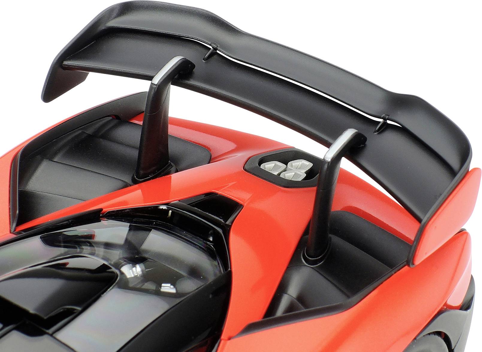 Nahaufnahme eines roten Sportwagen-Hecks mit einem großen, geschwungenen Heckspoiler und Belüftungsschlitzen.