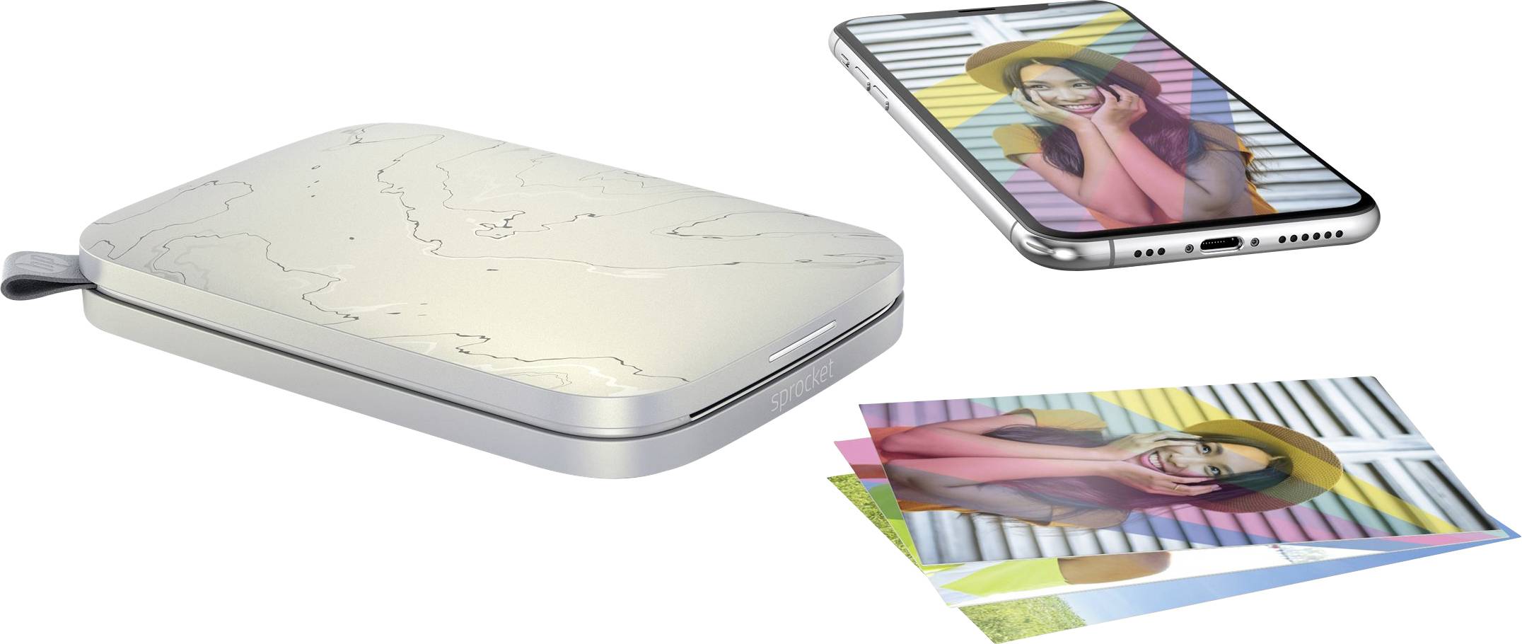 Ein tragbarer Fotodrucker neben einem Smartphone und gedruckten Fotos eines lächelnden Models, das vor einem gestreiften Hintergrund posiert.