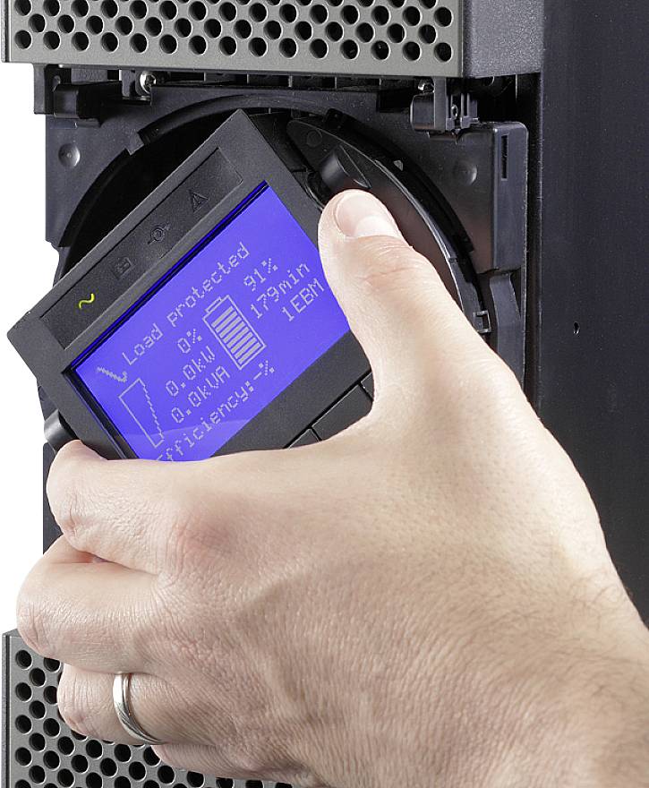 Eine Hand entfernt eine Backup-Bandkassette aus einem Laufwerk. Auf dem Display sind Statusinformationen zur Datensicherheit und Speichernutzung sichtbar.