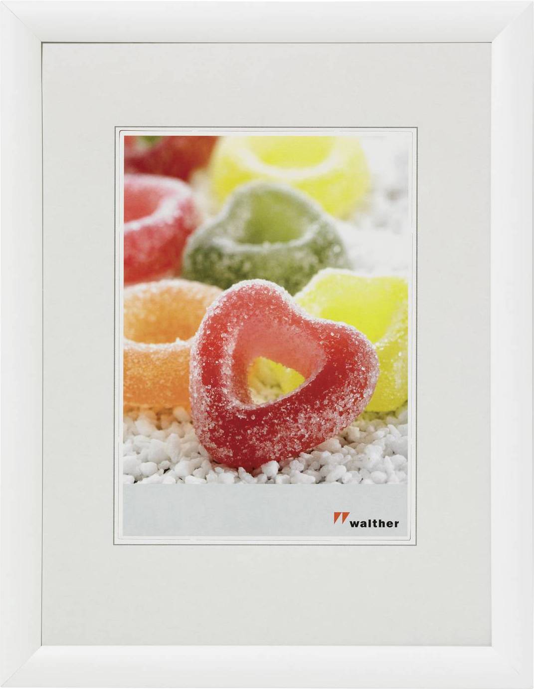 Verschiedene bunte, zuckerüberzogene Fruchtgummiringe auf weißem Hintergrund in einem weißen Bilderrahmen.