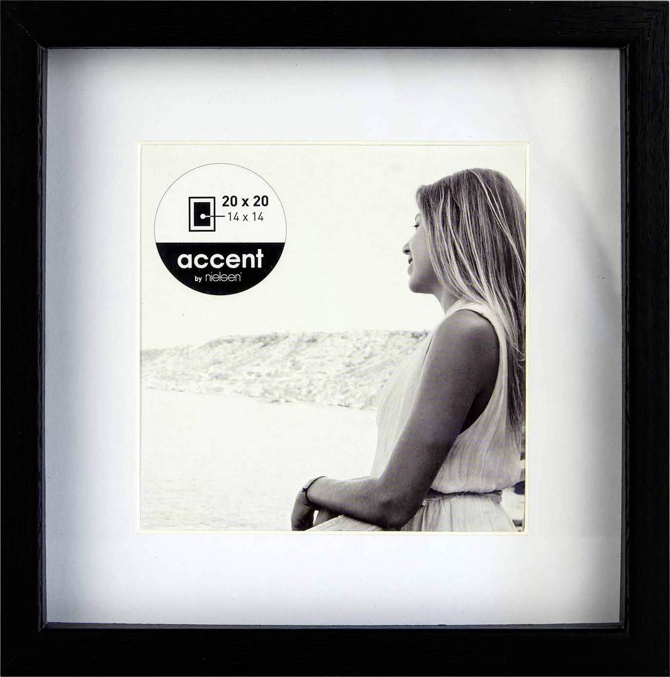 Eine Frau in einem weißen Kleid steht an einem Gewässer, blickt nach rechts. Im Bild steht 'accent by nielsen 20 x 20 14 x 14'.