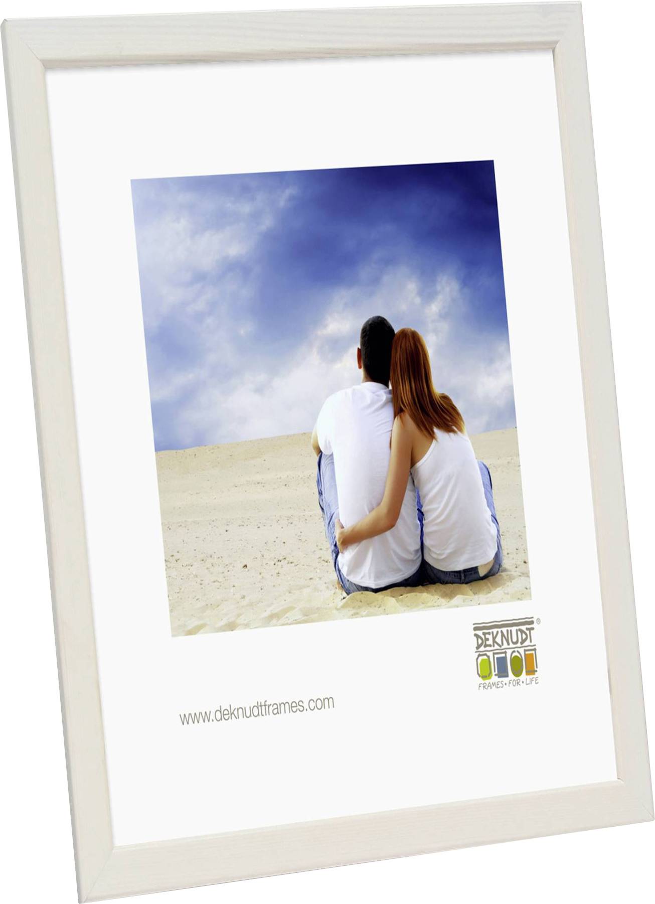 Ein Paar sitzt am Strand und schaut in einen bewölkten Himmel. Sie tragen weiße Kleidung.