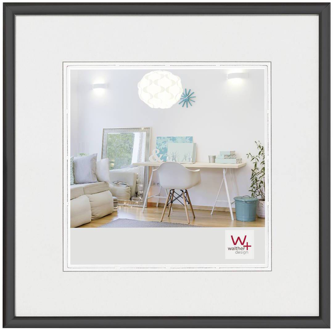 Hausinnenraum mit einem hellen, modernen Arbeitsbereich: Schreibtisch, Stuhl, Sofabereich und Lampe. Wandfarbe ist weiß.