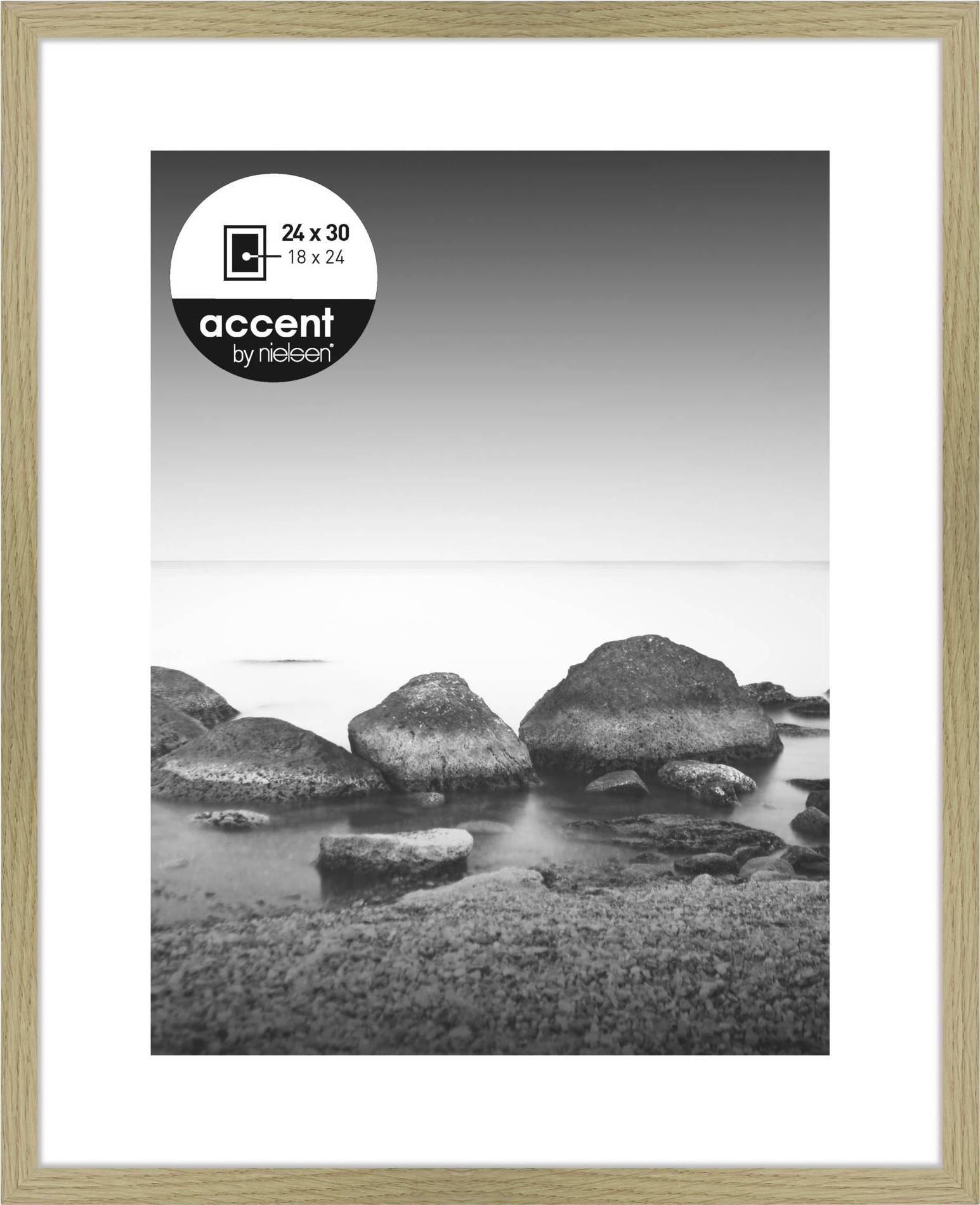 Schwarzweißfoto von Felsen in einem ruhigen Wasser. Rahmen aus hellem Holz, Größe 24 x 30 cm. Oben links befindet sich ein rundes Label.