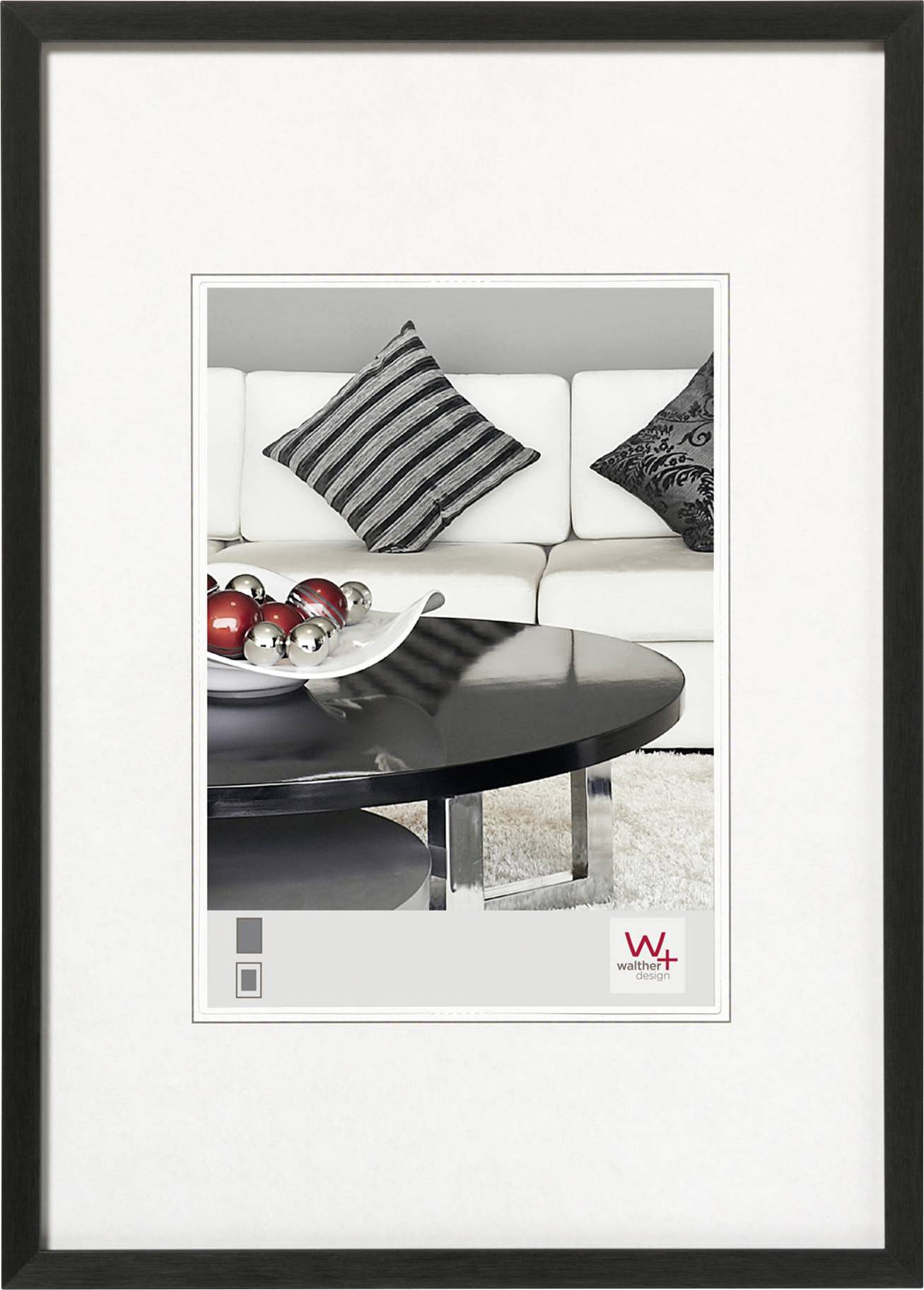 Ein modernes Wohnzimmer mit weißem Sofa, gestreiften Kissen und einem schwarzen Couchtisch, dekoriert mit roten und silbernen Kugeln.