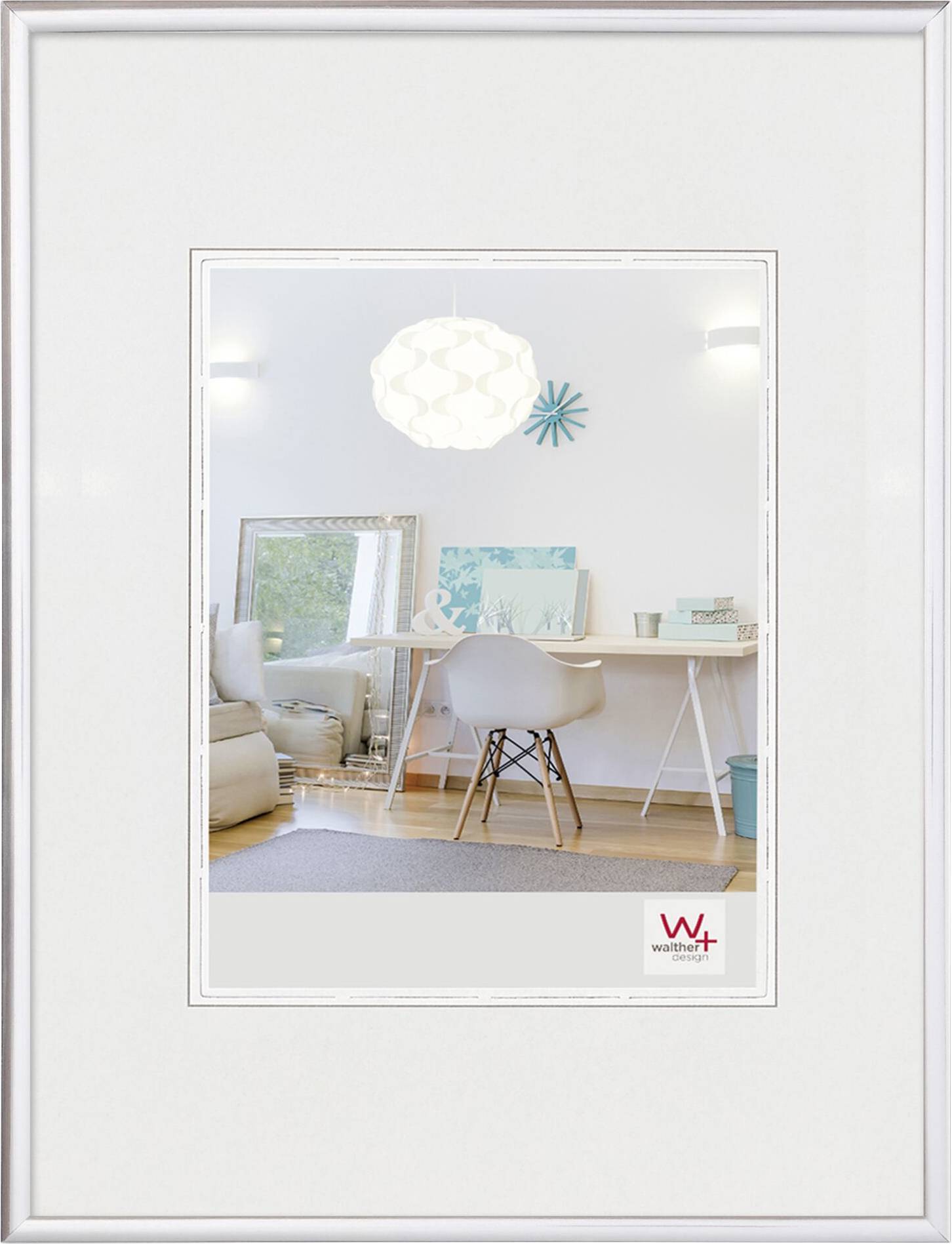 Ein modernes Wohnzimmer mit weißem Schreibtisch, Eames-Stuhl und Dekoration in Türkis. Ein großer Spiegel reflektiert den Raum.