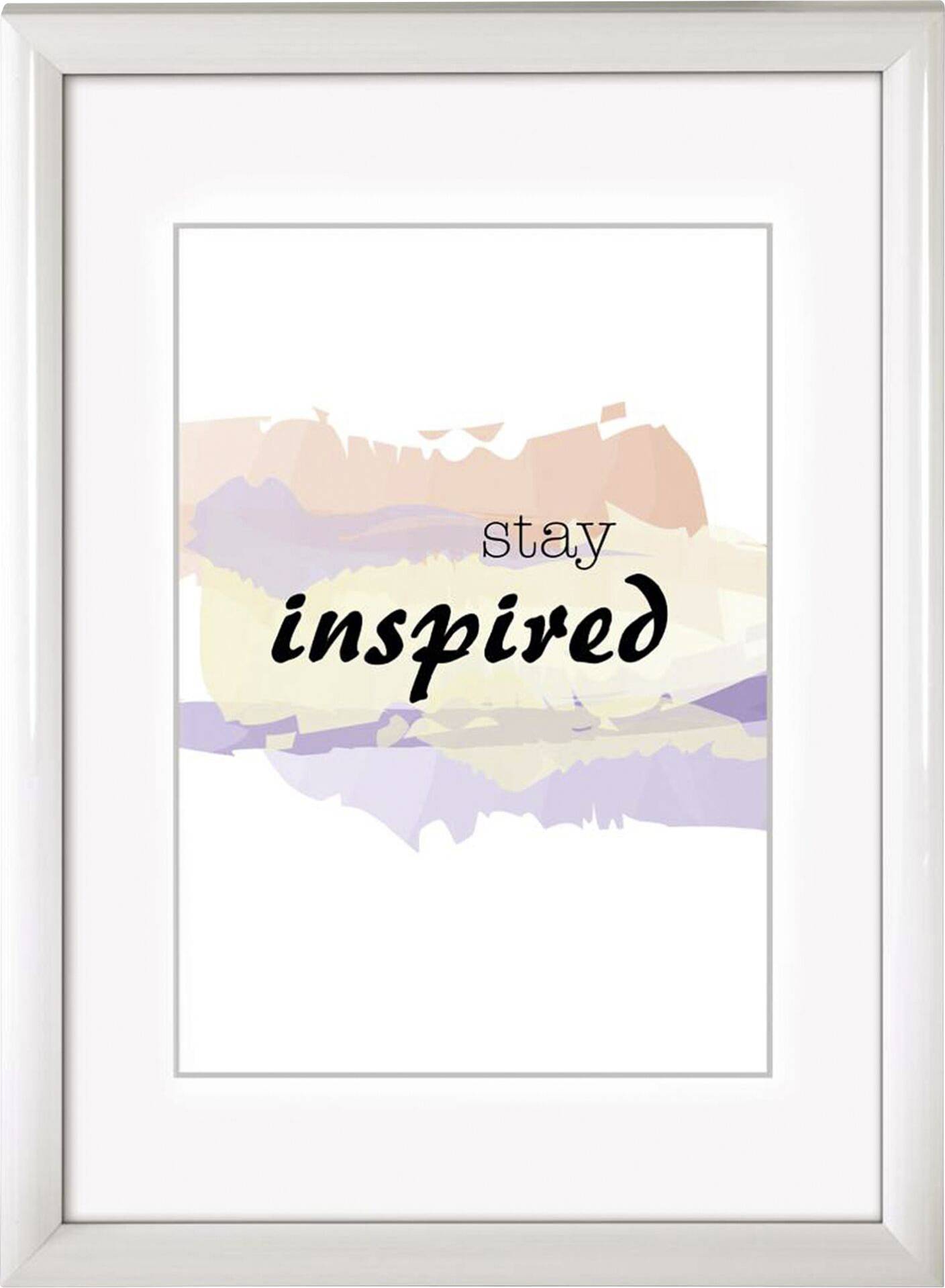 Gerahmter Kunstdruck mit dem Text 'stay inspired' auf farbigem Aquarell-Hintergrund.