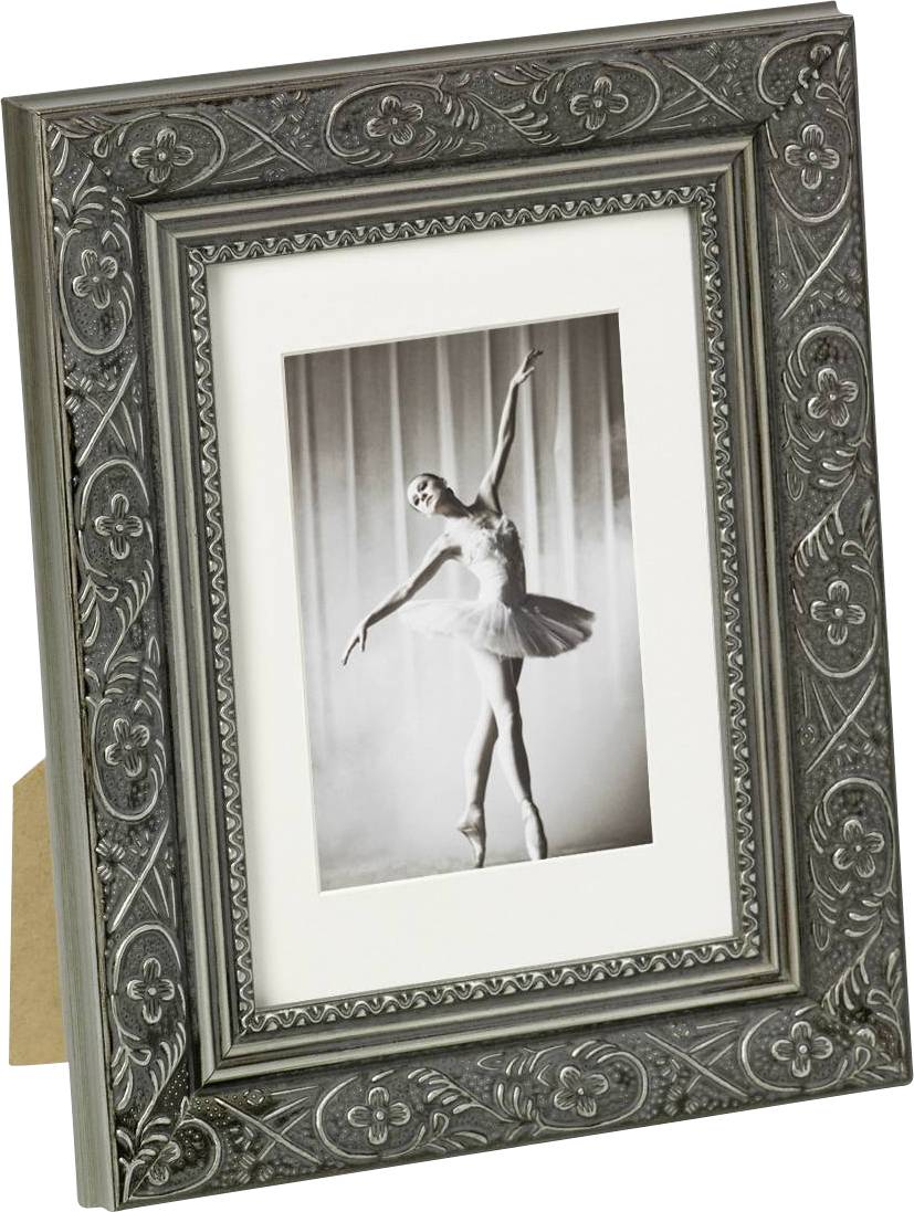 Ein gerahmtes Schwarz-Weiß-Foto zeigt eine Balletttänzerin in eleganter Pose auf Zehenspitzen, umgeben von einem reich verzierten Rahmen.