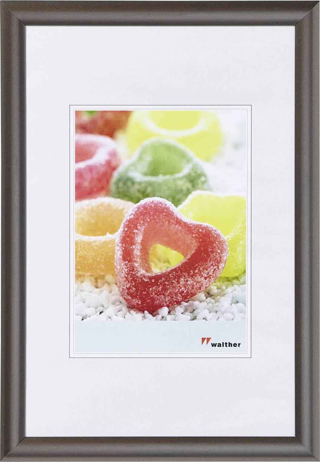 Bunte, gezuckerte Fruchtgummis in Herzform liegen auf weißen Kristallen. Ein rotes Herz ist im Vordergrund.