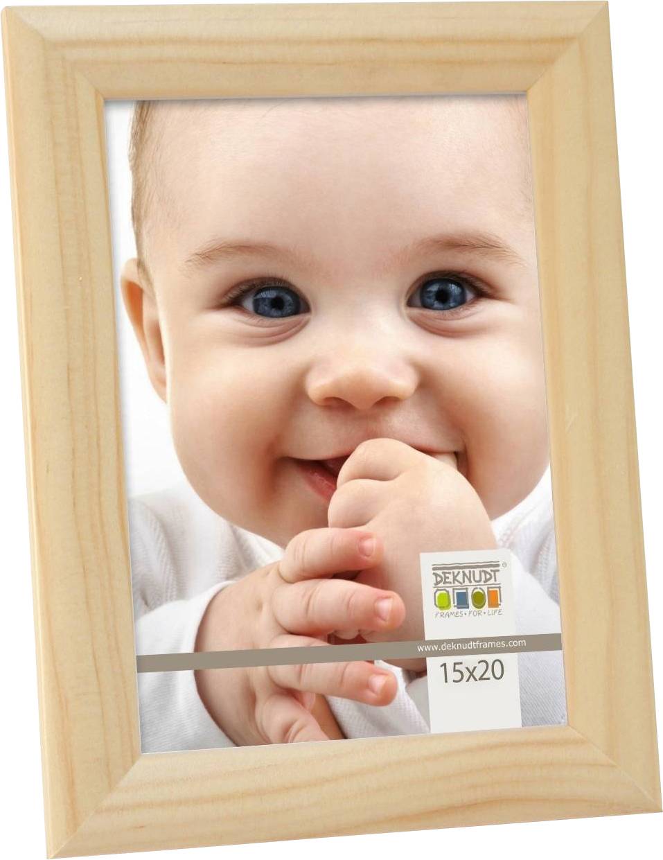 Ein Baby lächelt fröhlich in die Kamera. Es hat blaue Augen und hält die Hände vor das Gesicht. Der Holzrahmen hat das Format 15x20.