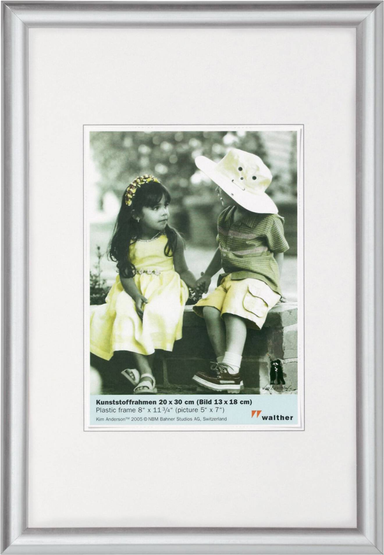 Ein schwarz-weiß Foto von zwei Kindern. Das Mädchen trägt ein gelbes Kleid, der Junge einen Hut. Umrandet von einem schlichten Rahmen mit Informationen unten.
