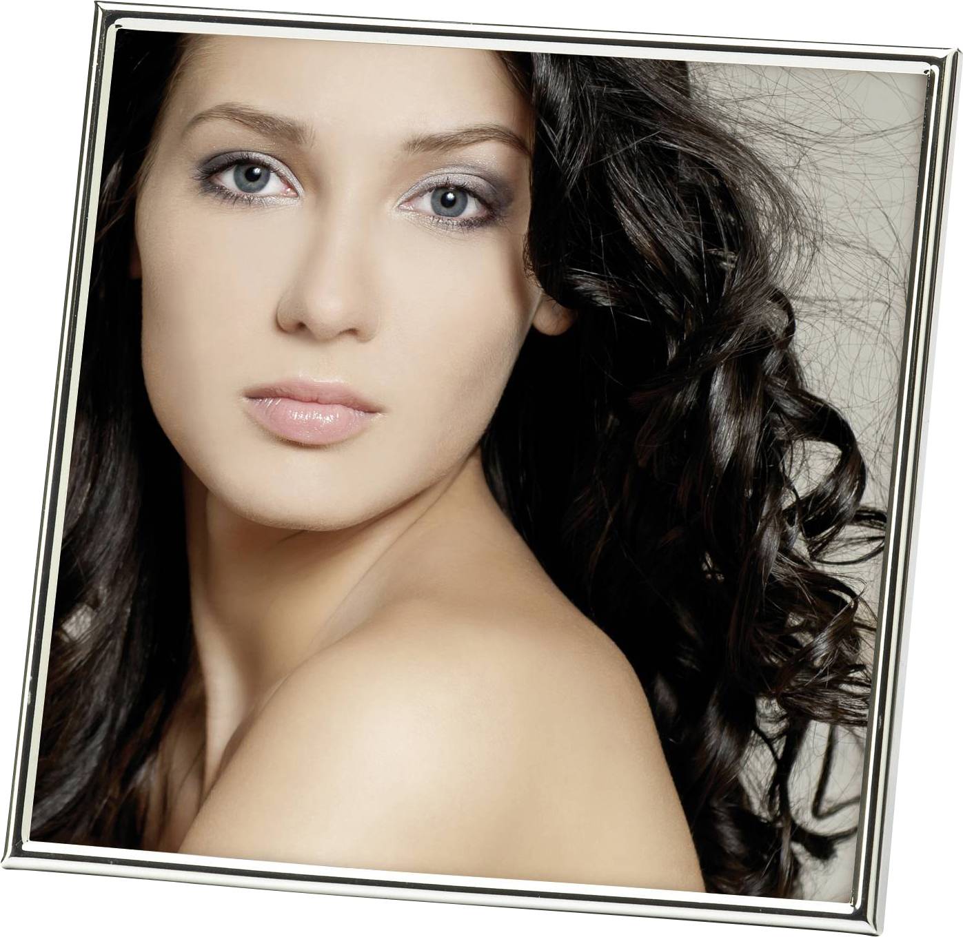 Eine Frau mit langen, lockigen, dunklen Haaren und einem entspannten Gesichtsausdruck blickt direkt in die Kamera.